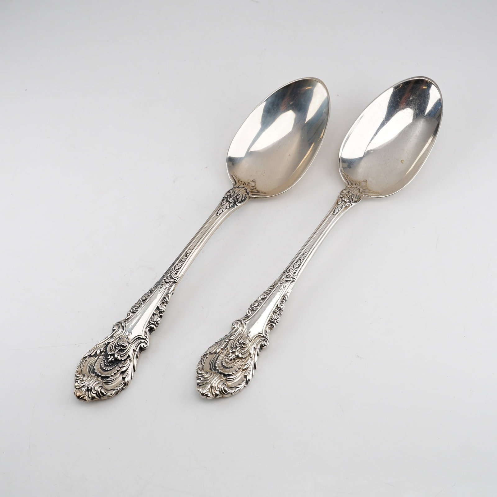 Pair of Wallace Sterling Silver Dessert Spoons, Sir Christopher Pattern: A pair of solid .925 sterling silver dessert spoons manufactured by Wallace Silversmiths in the Sir Christopher pattern. This pattern, designed by William S. Warren and introduced in 1936, features an