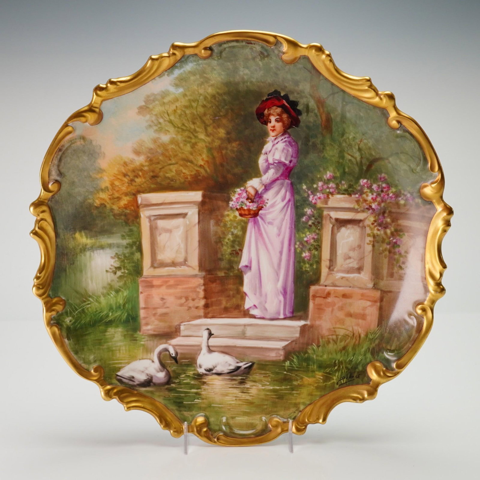 Limoges France Hand-Painted Porcelain Wall Plate Signed Dubois: This French porcelain cabinet plate features a central decoration with a fine hand-painted garden landscape depicting a woman in late 19th-century attire, including a lilac-colored gown and a red-ribb