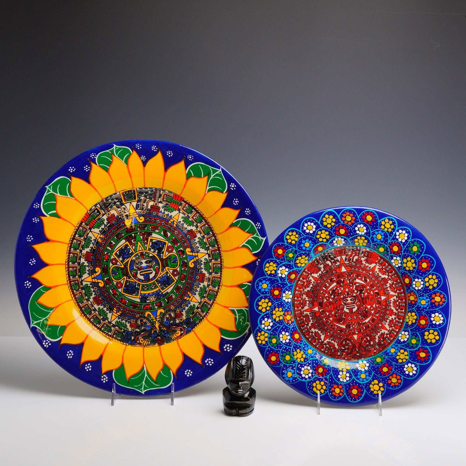 3pc Ceramic Native American Art Platters and Carved Stone Figure: This lot consists of three items of folk art, including two decorative earthenware plates and a small carved stone figurine. The larger plate is crafted from buff-colored clay with a cobalt blue glaze