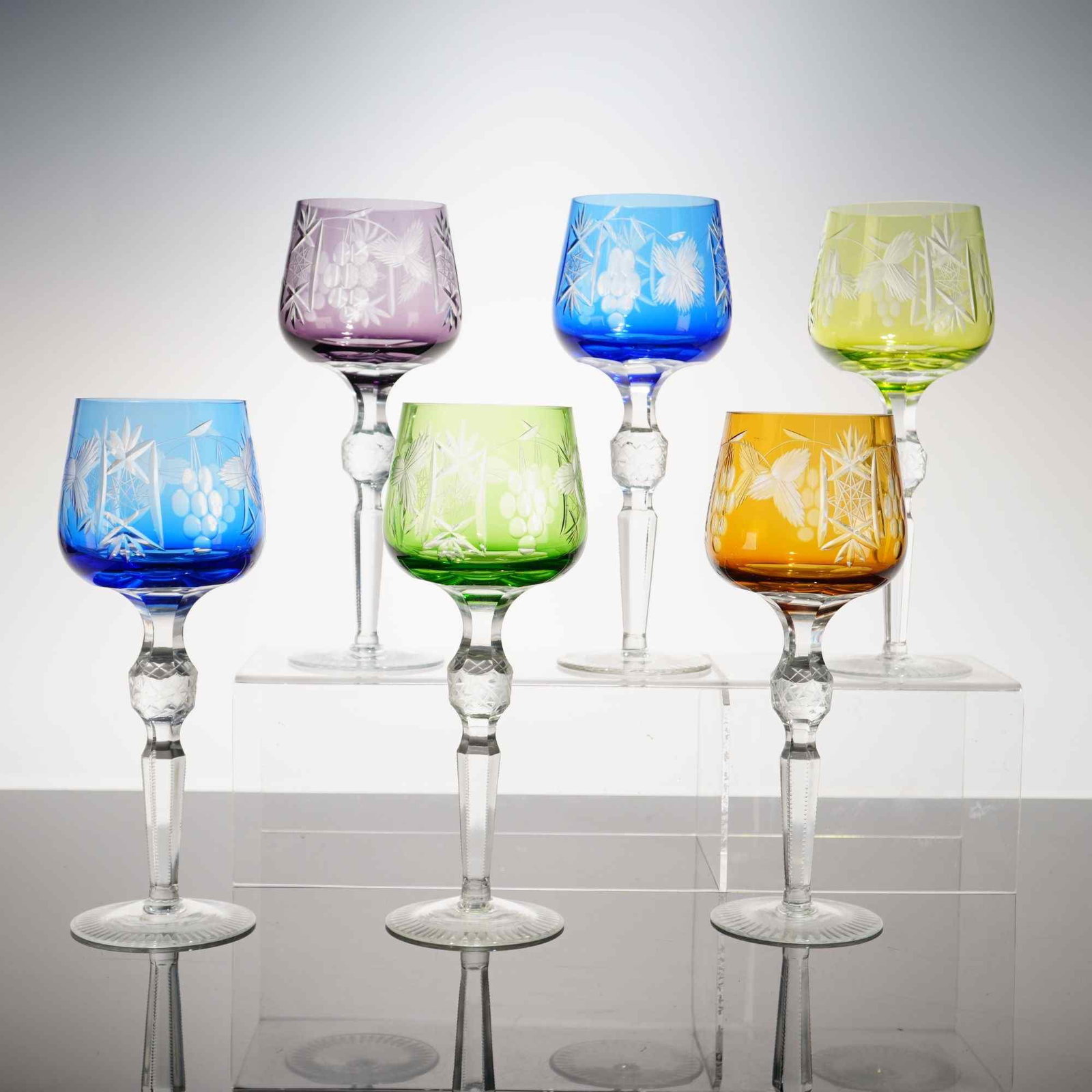 Set of 6 Colored Bohemian Cut-to-Clear Crystal Wine Glasses in the Traube Pattern: This set of six hock or wine glasses is produced in the traditional Bohemian cut-to-clear style. The harlequin set features bowls in six distinct colors: amethyst, cobalt blue, chartreuse, sky blue, e