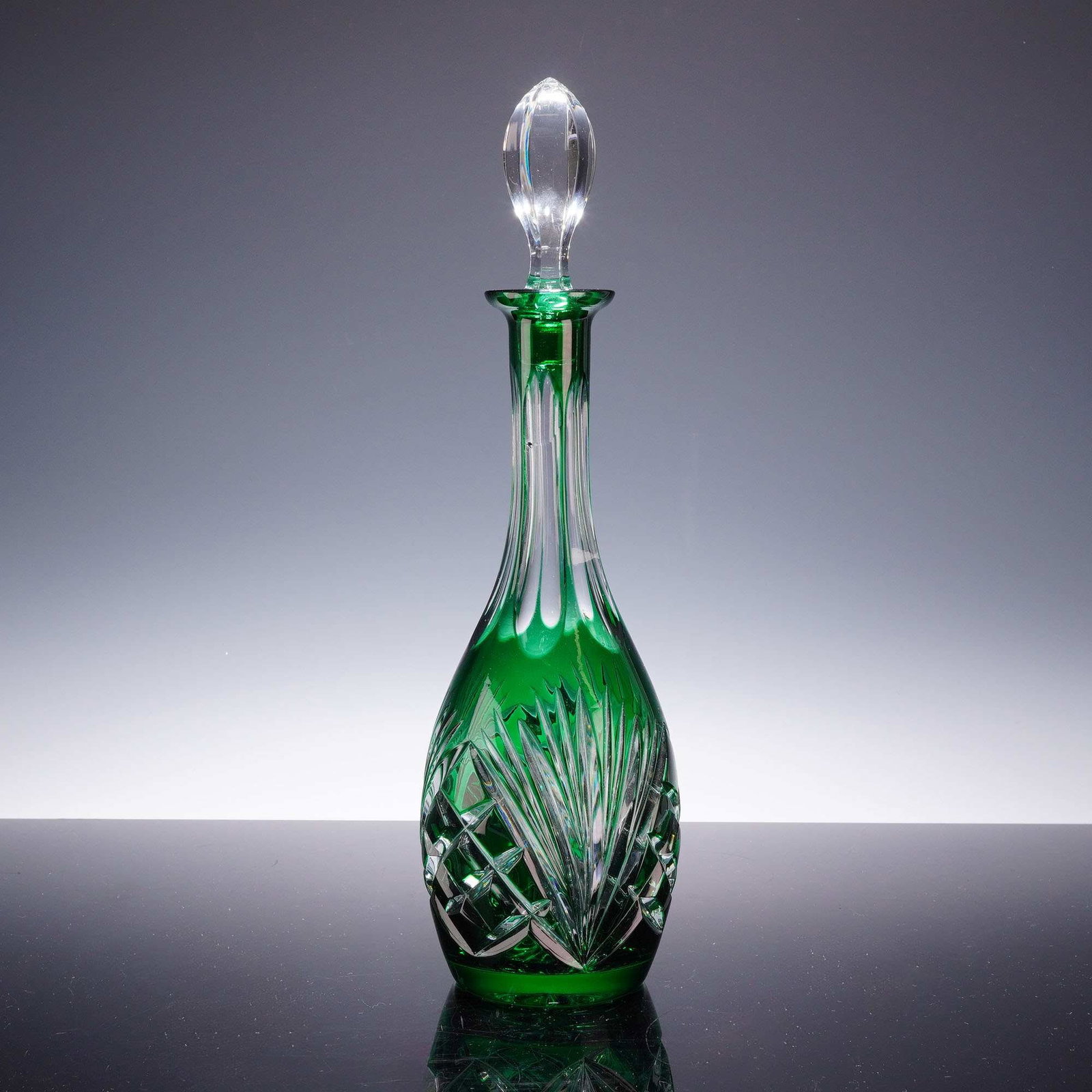 Gorham Emerald, Green Cut-to-Clear Crystal Decanter with Stopper: This emerald, green cut glass decanter with stopper is manufactured from high-quality lead crystal with a vibrant emerald, green casing. The piece features an intricate, deep radial cutting pattern wh