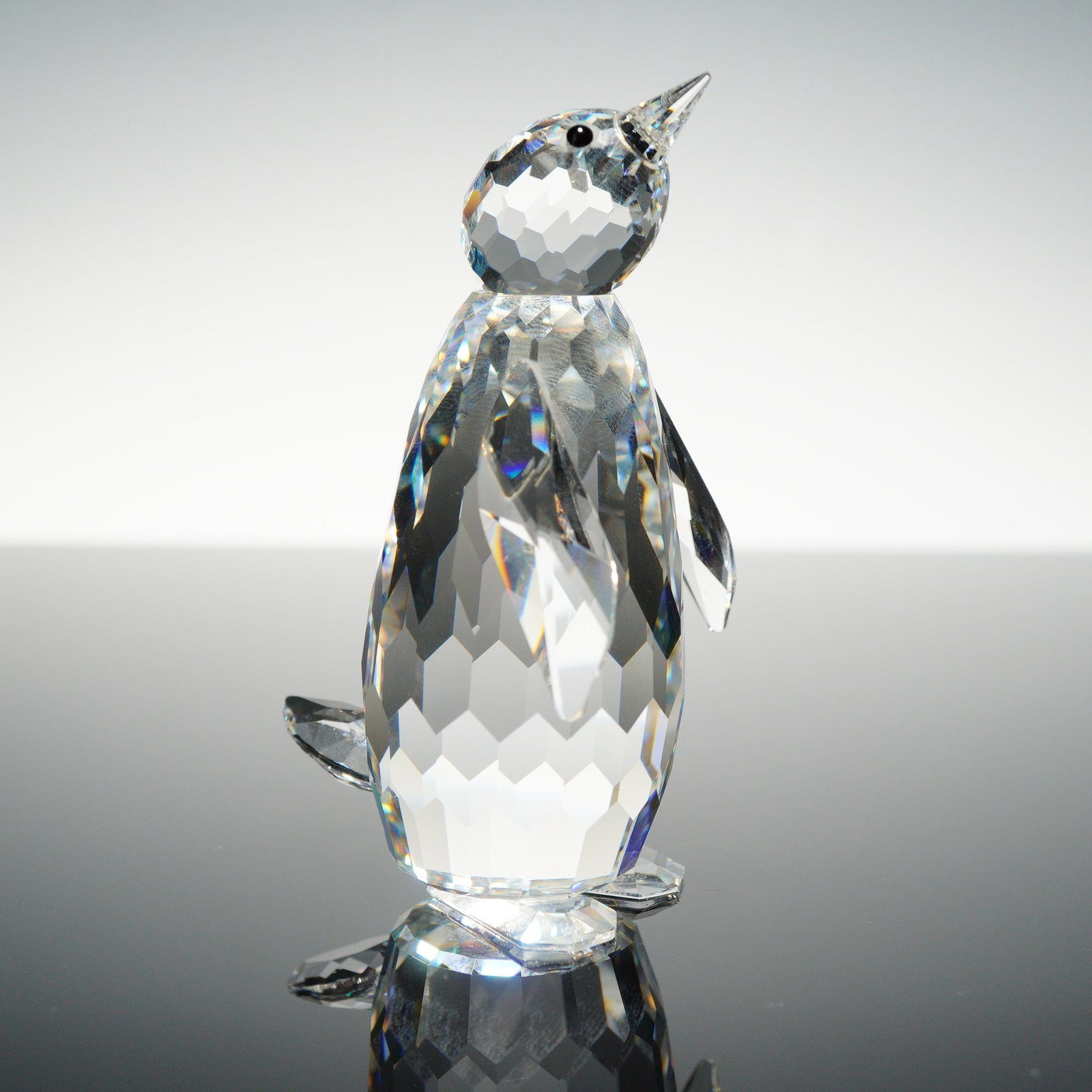 Swarovski Silver Crystal Large Penguin Figurine: A Swarovski lead crystal figurine from the Silver Crystal line depicting a standing penguin. The penguin is rendered in a pose with its head tilted upward and slightly to the right. The figurine featu