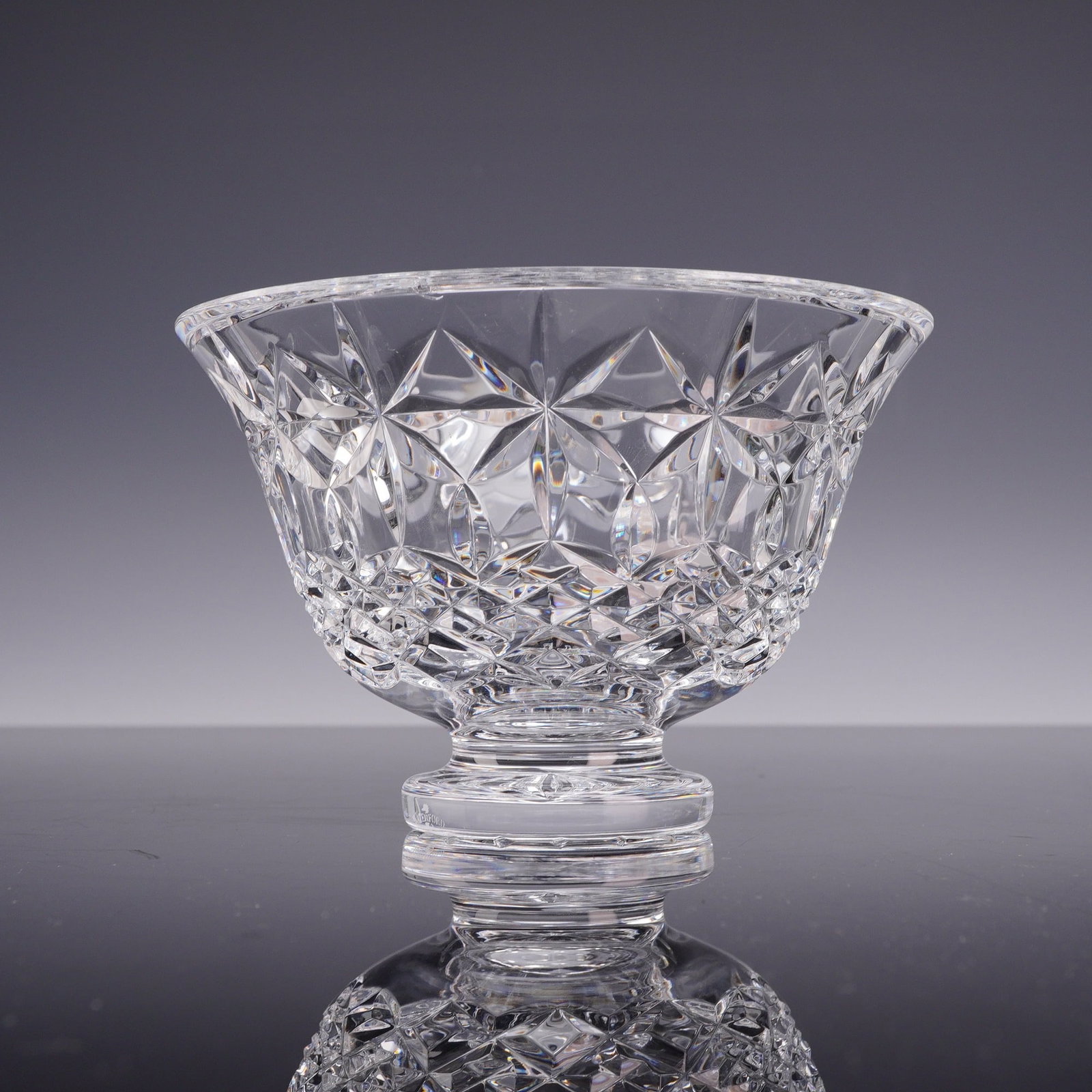 Waterford Crystal Balmoral Pattern Footed Bowl: A lead crystal footed bowl produced by Waterford in the Balmoral pattern. The vessel features a flared rim and a deep tapered body decorated with a combination of precision-cut designs. The upper sect