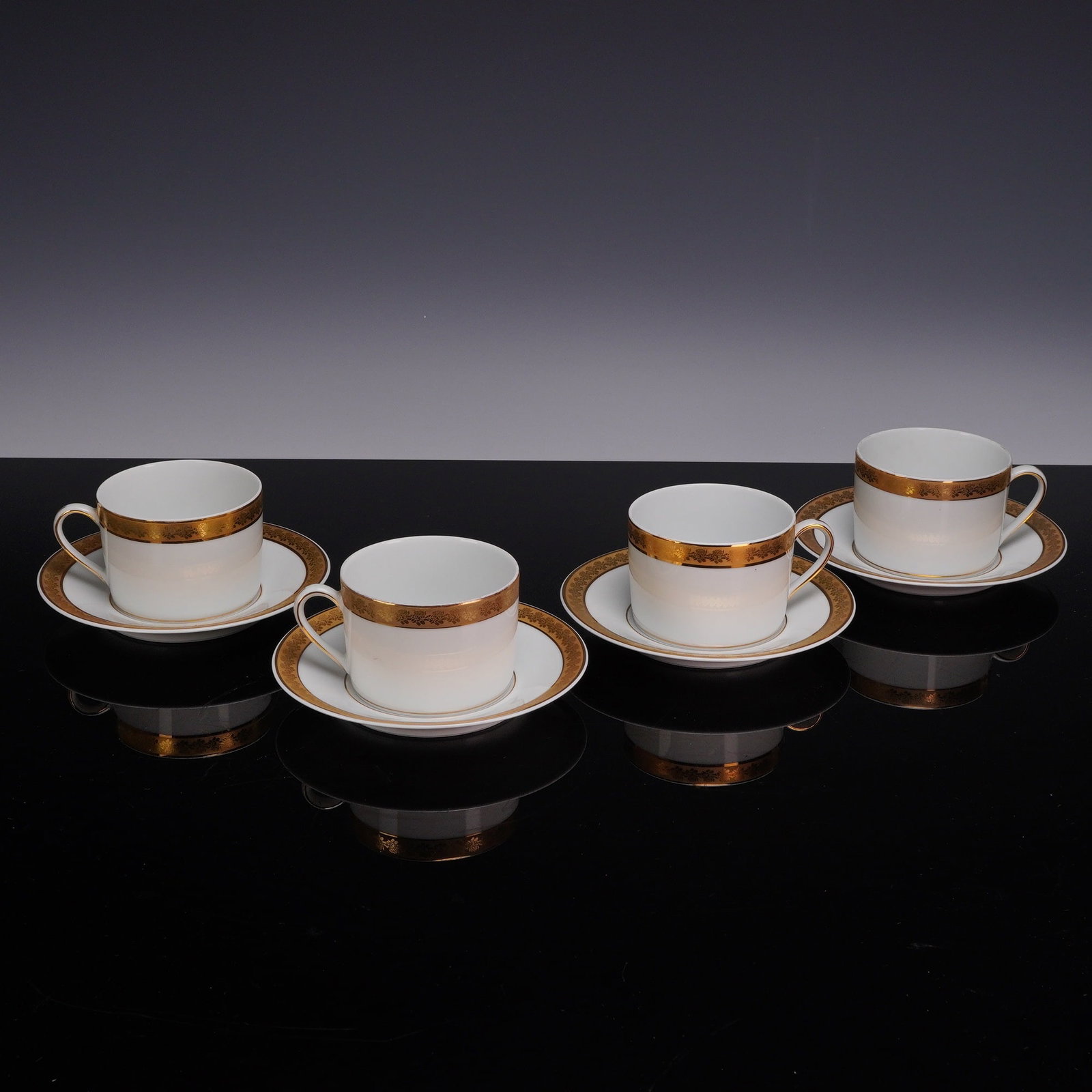 8pc Bernardaud Limoges Porcelain Rhapsody Tea Cups and Saucers: A set of eight porcelain pieces comprising four tea cups and four matching saucers from the Rhapsody pattern by Bernardaud, Limoges. Each piece is crafted from white porcelain and decorated with a wid