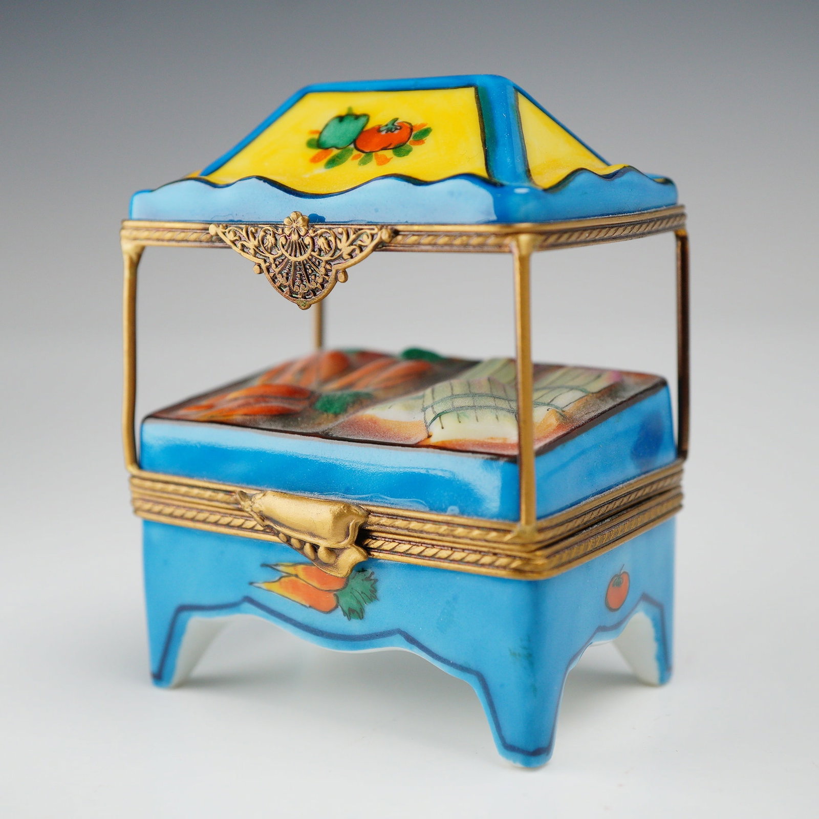 Limoges France Eximious Hand-Painted Porcelain Market Stall Trinket Box: A French porcelain hinged treasure box produced in Limoges for the luxury retailer Eximious. The piece is modeled in the form of a miniature market stall or vegetable stand. The construction features 
