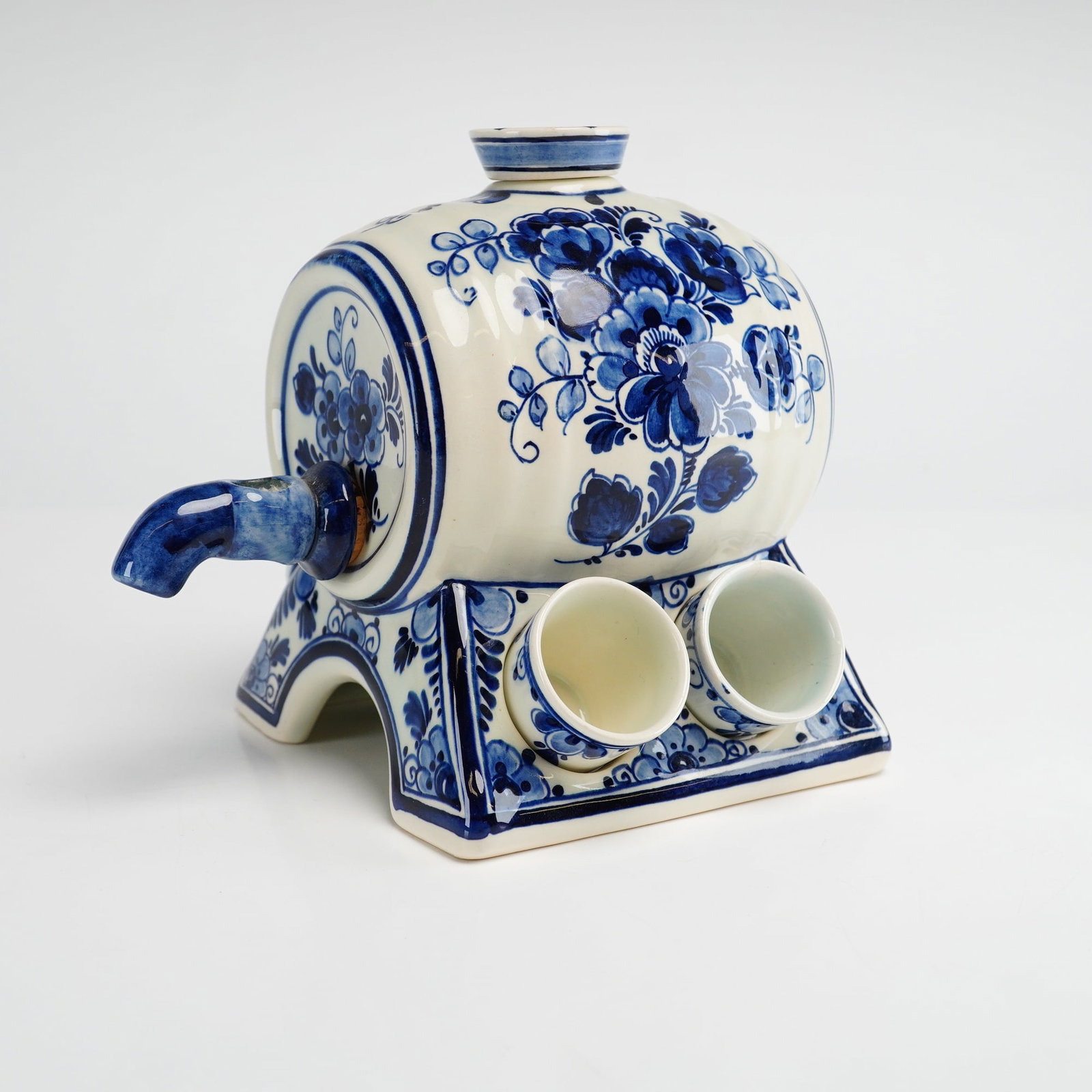 5pc Set of Delfts Blauw Hand Painted Ceramic Liqueur Barrel Dispenser and Miniature Cups: A Dutch ceramic liqueur or cordial set crafted in Holland. The set features a miniature barrel-shaped dispenser on an integrated four-legged stand, accompanied by four matching miniature cups. Each pi