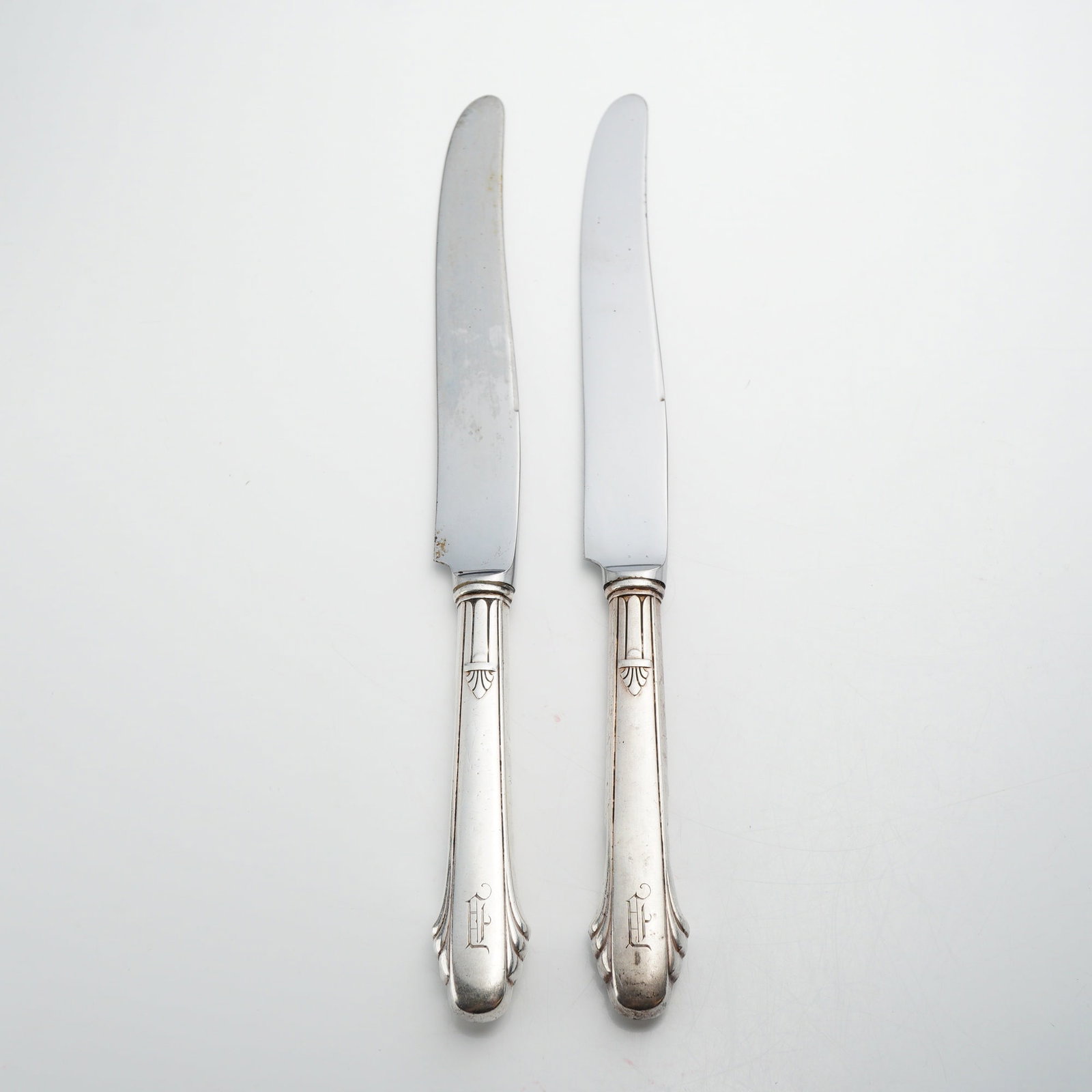 Pair of Gorham Sterling Silver Handled Table Knives: A pair of sterling silver handled knives produced by the Gorham Manufacturing Company, which was first introduced in 1936. These knives feature hollow sterling silver handles paired with stainless