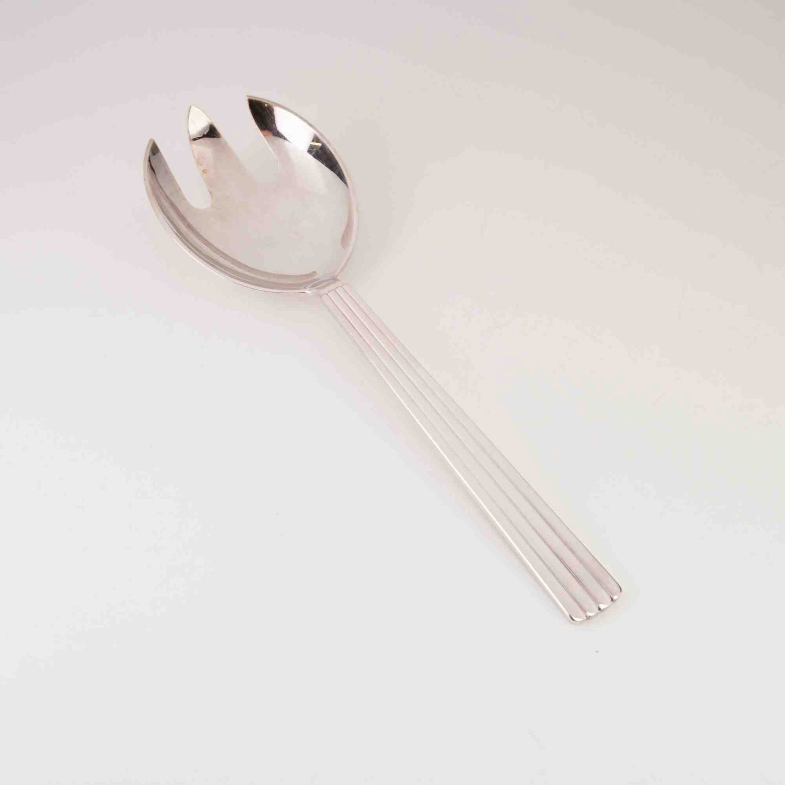 Georg Jensen EPNS Bernadotte Pattern Salad Serving Fork: A Georg Jensen salad serving fork in the Bernadotte pattern. This piece showcases the signature Art Deco-inspired vertical fluting on the handle, a design originally created by Sigvard Bernadotte in