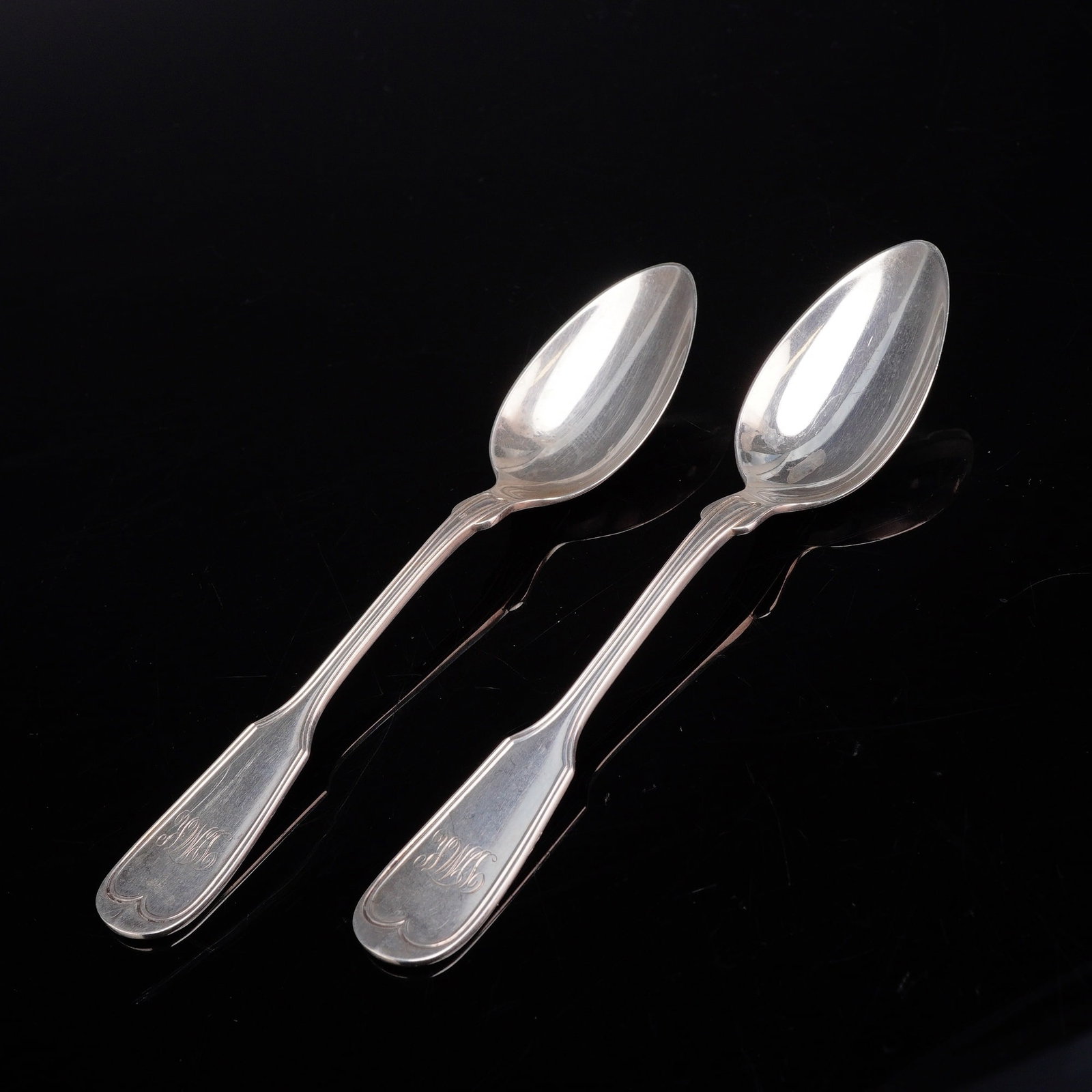 A Pair of Frank W. Smith Silver Co. Sterling Silver Fiddle Thread Pattern Teaspoons: A pair of sterling silver spoons by Frank W. Smith Silver Co. Each piece is designed in the Fiddle Thread pattern, featuring a classic fiddle-shaped handle with a raised thread border and rounded term