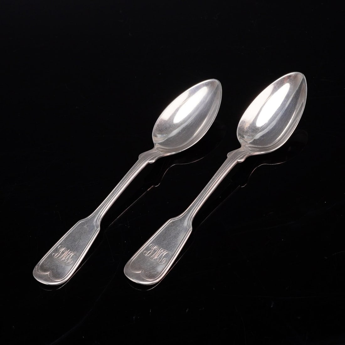 A Pair of W. Carrington and Co. Sterling Silver Fiddle Thread Pattern Spoons: A pair of tested sterling silver spoons manufactured by W. Carrington and Co. of Charleston, South Carolina. These spoons are designed in the traditional Fiddle Thread pattern, featuring a handle