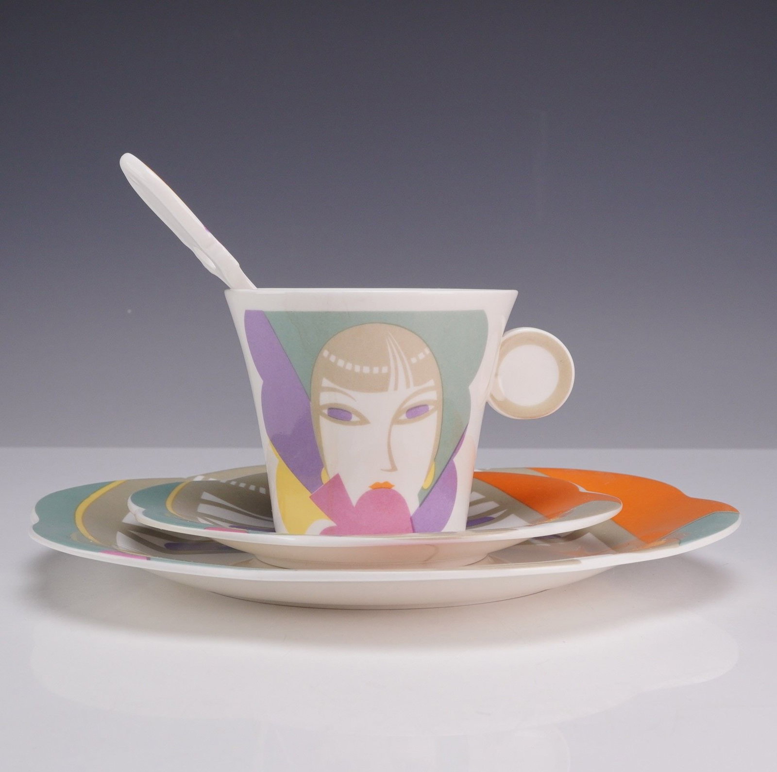 4 Piece Sango Larry Laslo Dessert Set - Plate, Saucer, Teacup and Stirrer, Visage: This four-piece glazed porcelain set features the Visage pattern from The Larry Laslo Collection for Sango. Produced in 1986, the set is decorated with an Art Deco-influenced stylized female face in