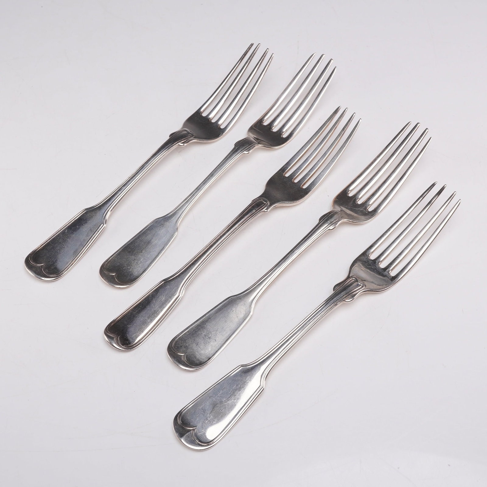 5pc Sterling and Coin Silver Forks: This set includes one sterling silver fork and four coin silver forks. Each fork features a curved heart-shaped motif on the handle, and the reverse side is stamped with their respective hallmarks. We