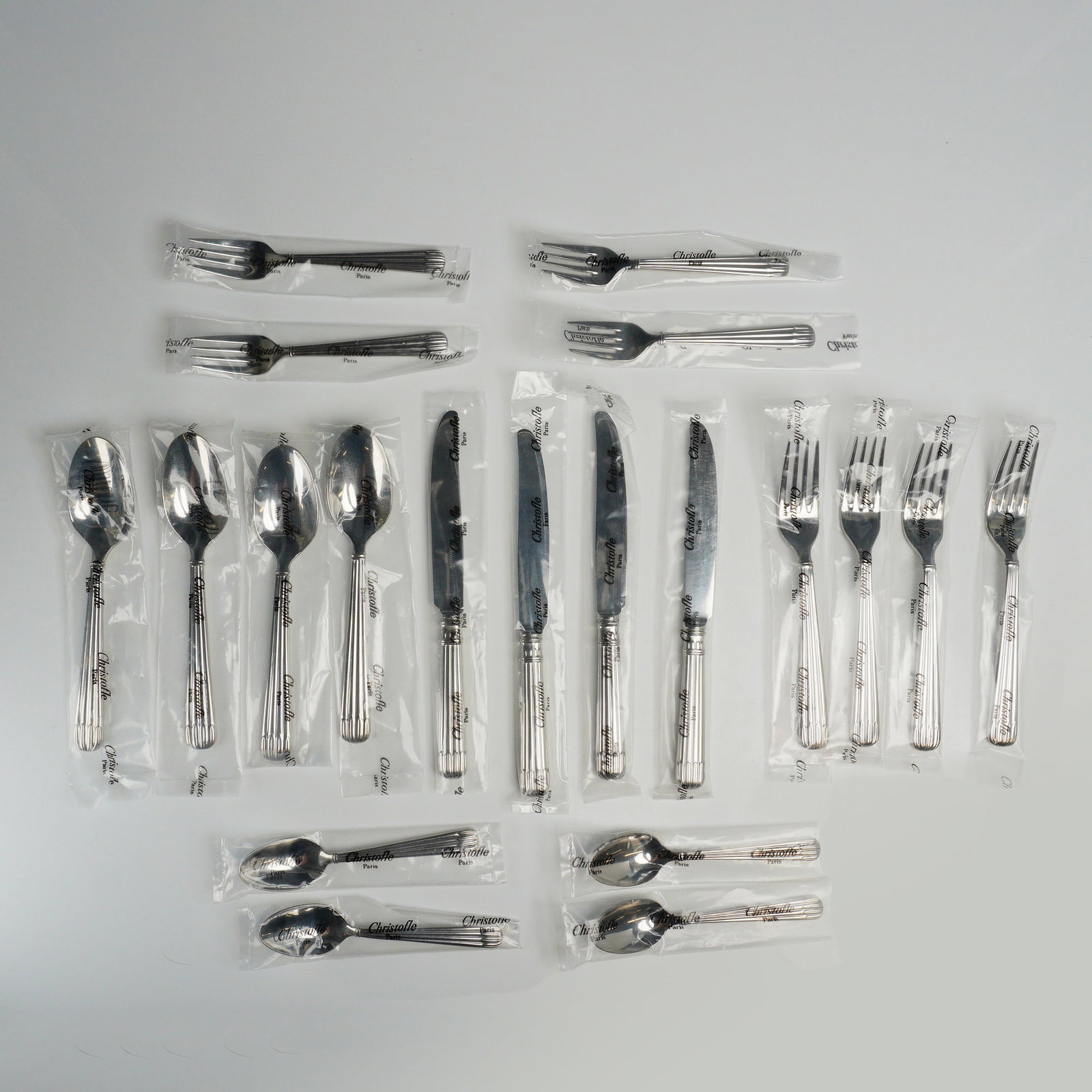 20pc Christofle Laguna Acier Stainless Steel Flatware Set for Four: A 20-piece stainless steel flatware service for four in the Laguna pattern by Christofle, France. The set includes four dinner forks, four salad forks, four dinner knives, four spoons, and four desser