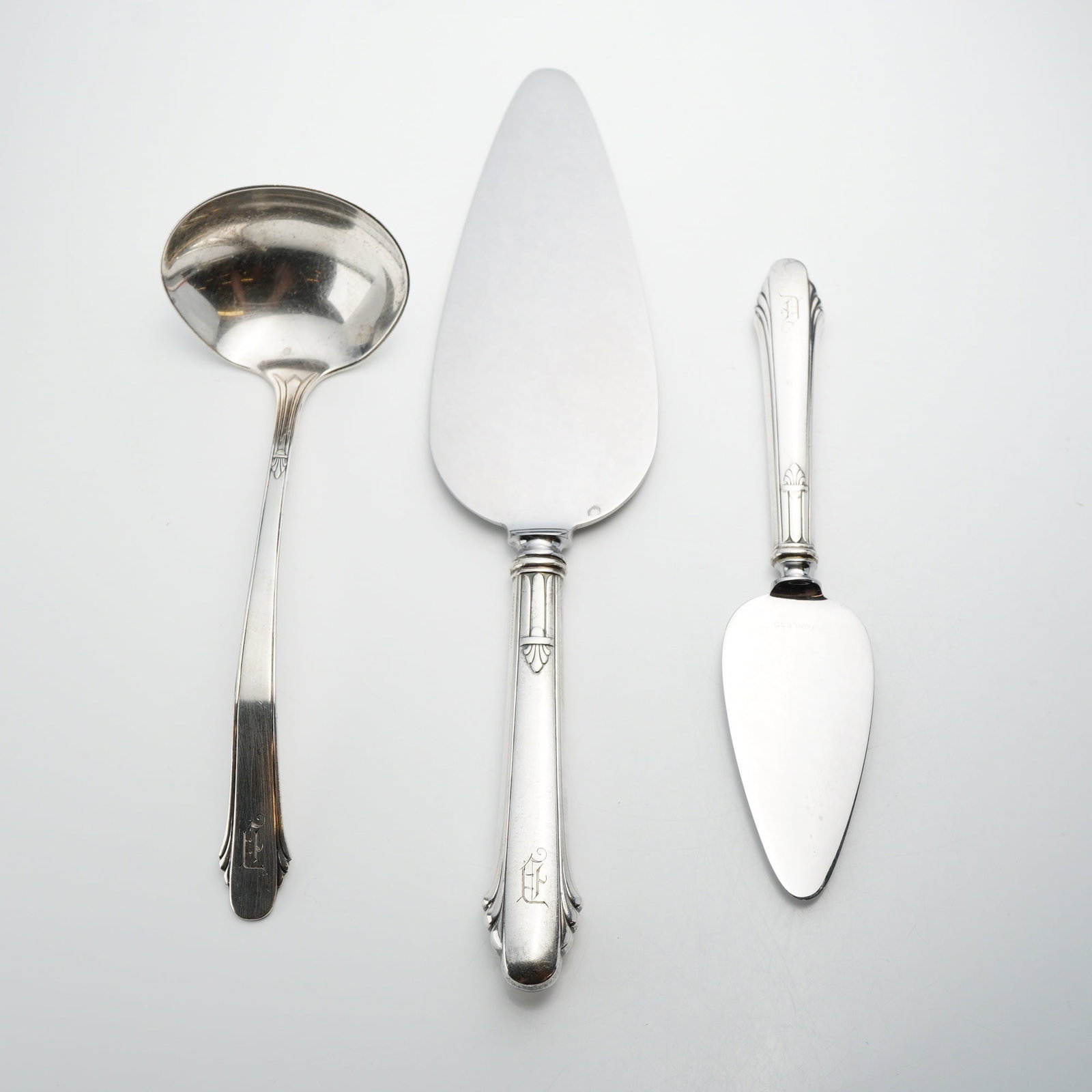 Three Gorham Sterling Silver Serving Utensils, Hunt Club Pattern: This lot of three Gorham sterling silver serving utensils is in the Sovereign pattern, featuring Art Deco influenced styling with a stylized fan or shell motif at the handle terminals and bolsters. Th