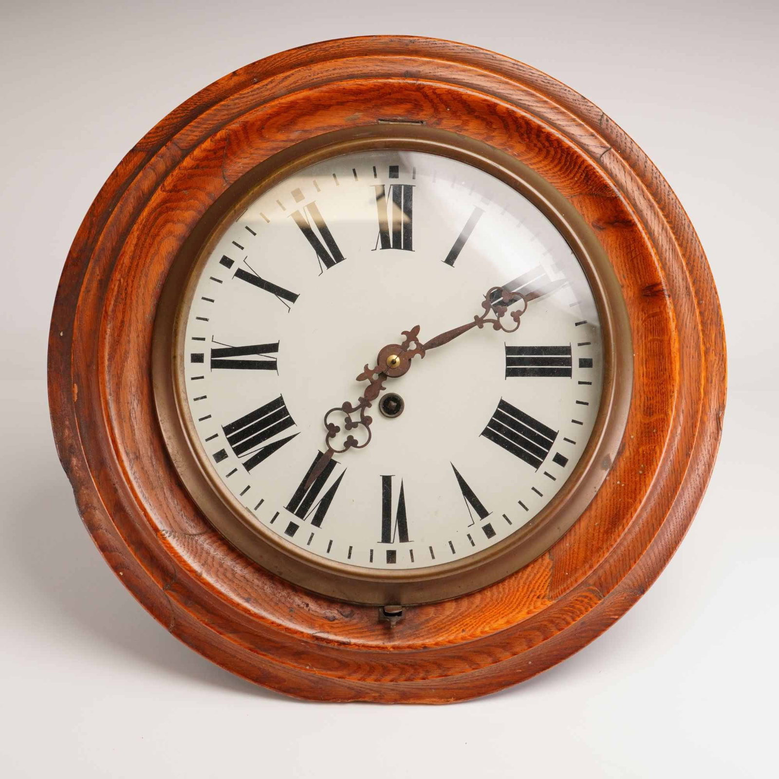 Wood Framed Wall Clock: This wall clock showcases a circular wooden case accented with a brass bezel. The classic design features an enamel dial displaying bold black Roman numerals. Weight: 4.12 lb