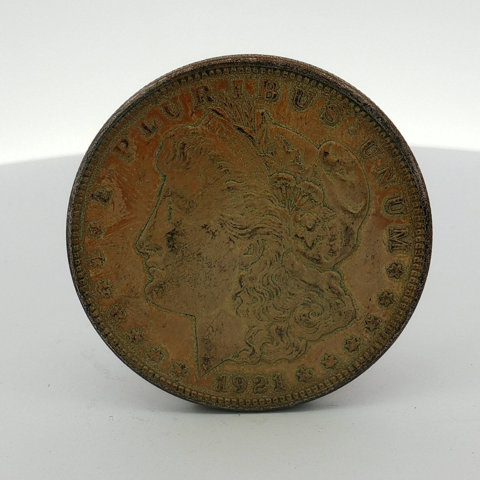 1921 US One Dollar Morgan Silver Dollar, Circulated: This coin features the Liberty Head obverse and the Eagle with wreath reverse. Struck at the Philadelphia Mint, the piece lacks a mint mark. The composition is 90 percent silver and 10 percent copper.