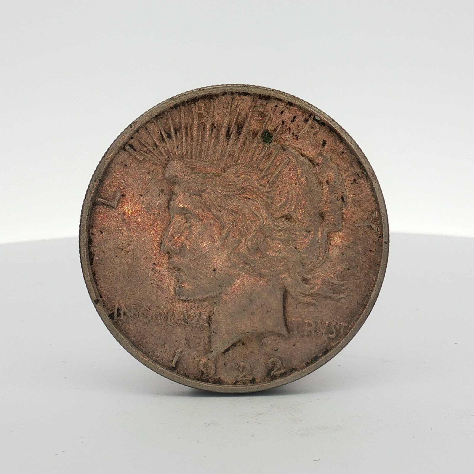 1922-D US One Dollar Silver Peace Dollar, Circulated: This US 1922 Peace Dollar is a silver-composition coin. The obverse features the Peace Dollar obverse design with the date 1922 and legends LIBERTY and IN GOD WE TRVST. The reverse features the Peace 