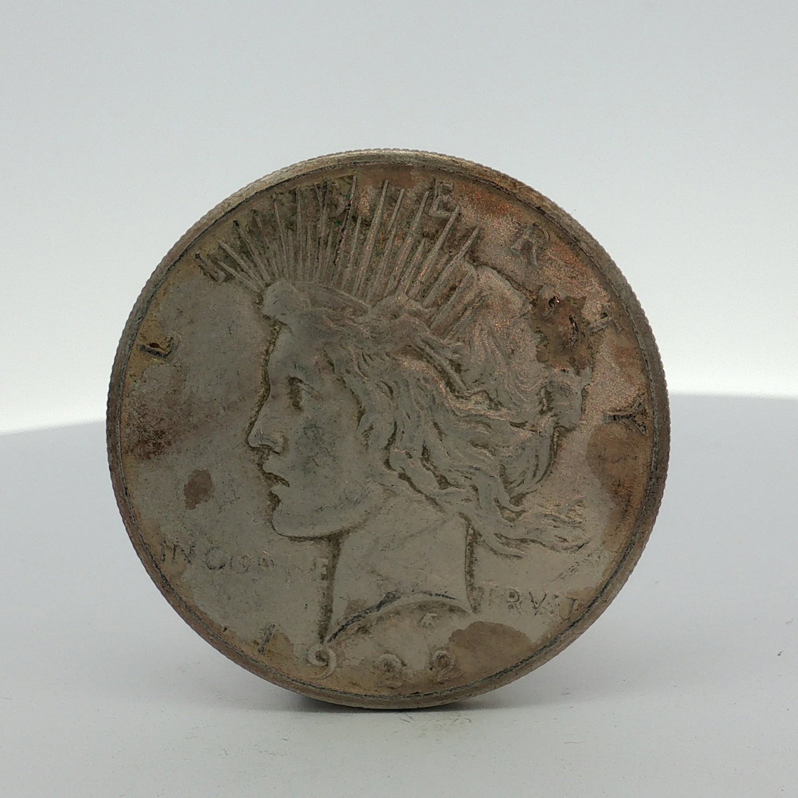 1922-S US One Dollar Peace Silver Dollar Coin, Circulated: This US Peace dollar is a 1922 San Francisco mint issue, composed of 90% silver and 10% copper. The obverse displays the date 1922 with inscriptions LIBERTY and IN GOD WE TRVST. The reverse S mint mar