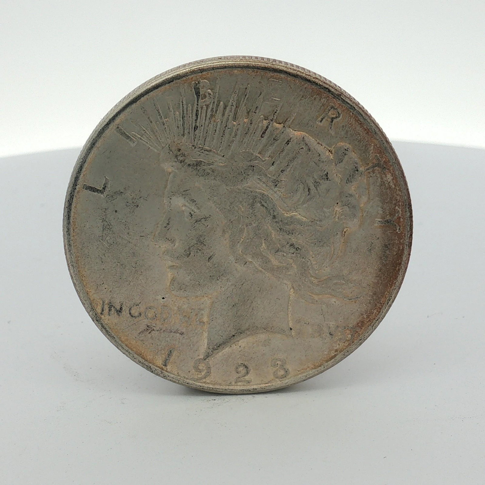 1923-D US One Dollar Peace Silver Dollar, Circulated: 1923-D US Silver Peace Dollar was struck at the Denver Mint and is composed of 90 percent silver and 10 percent copper. The obverse features the Liberty head design with inscriptions LIBERTY, IN GOD W