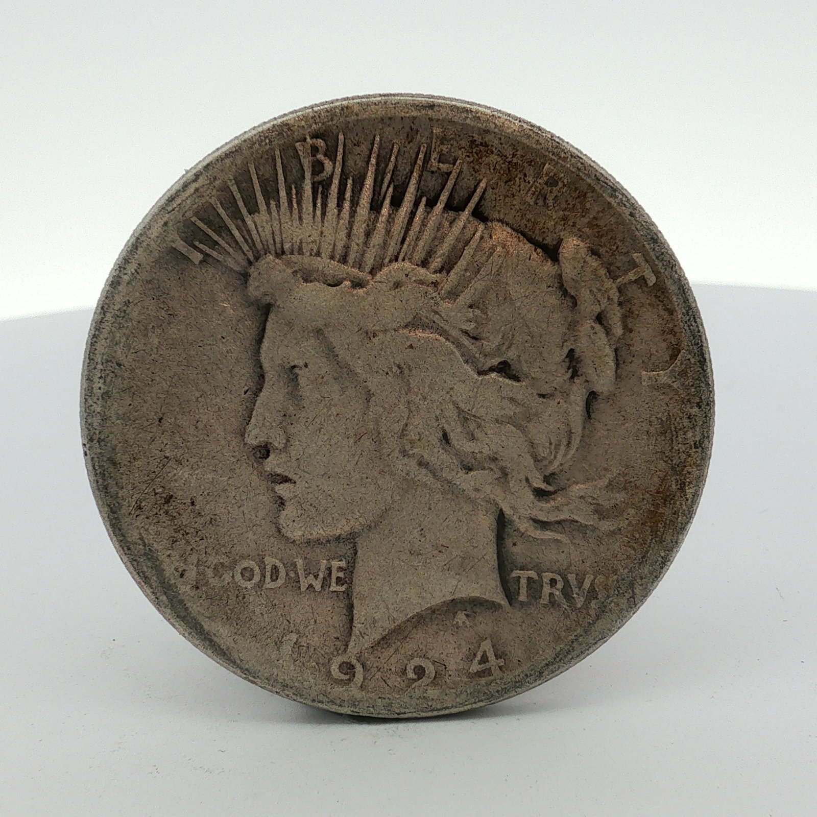 1924-S US One Dollar Peace Silver Dollar Coin, Circulated: This US 1924-S Peace silver dollar is an example of the silver dollar series struck at the San Francisco Mint. The obverse displays the 1924 date and the inscriptions associated with the Peace dollar 