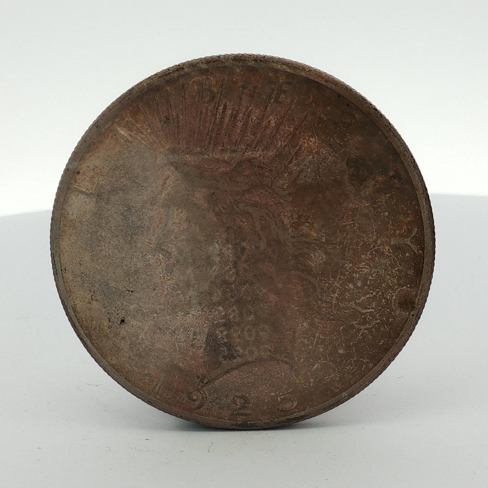 1925-S Peace Dollar: This silver coin features the Peace Dollar obverse and reverse designs. The date 1925 is visible at the base of the obverse. The reverse displays the inscriptions UNITED and ONE DOLLAR. The coin is co