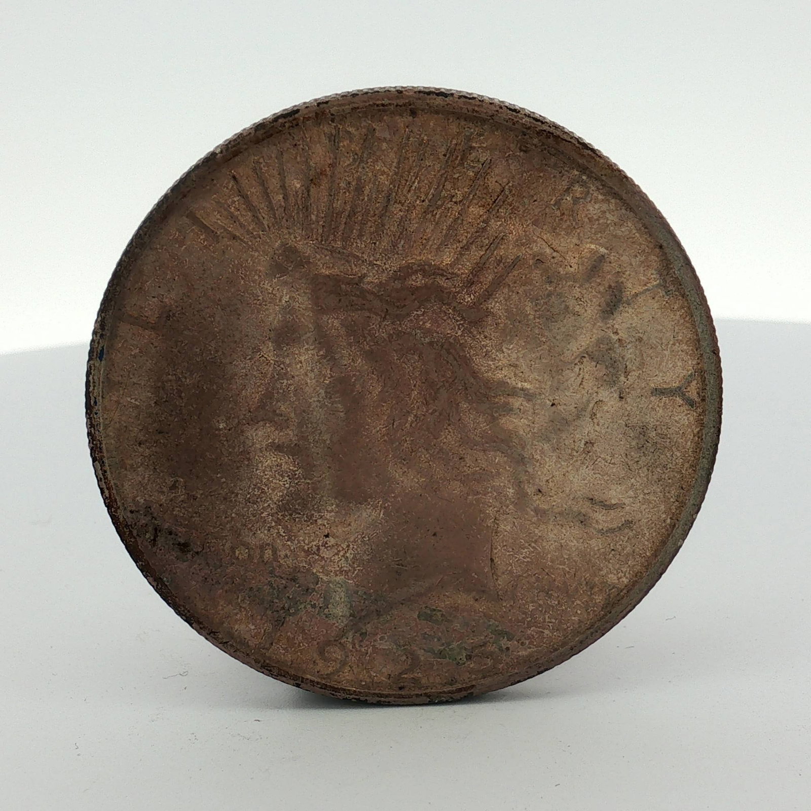 1925-S US Peace Silver Dollar: This US Peace dollar is a struck silver coin dated 1923. It is composed of .900 fine silver. The obverse features the Peace dollar design, and the reverse features the eagle on rock design. Visible in