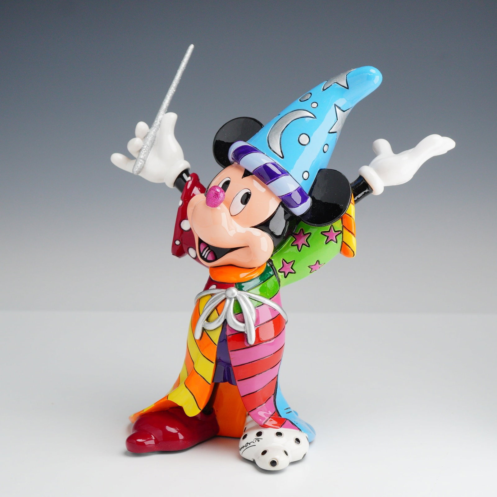 Disney by Britto Sorcerer Mickey Mouse Figurine: This Disney by Britto figurine depicts Mickey Mouse as the Sorcerer's Apprentice from the animated film Fantasia. The piece features the signature pop art style of artist Romero Britto. The figurine