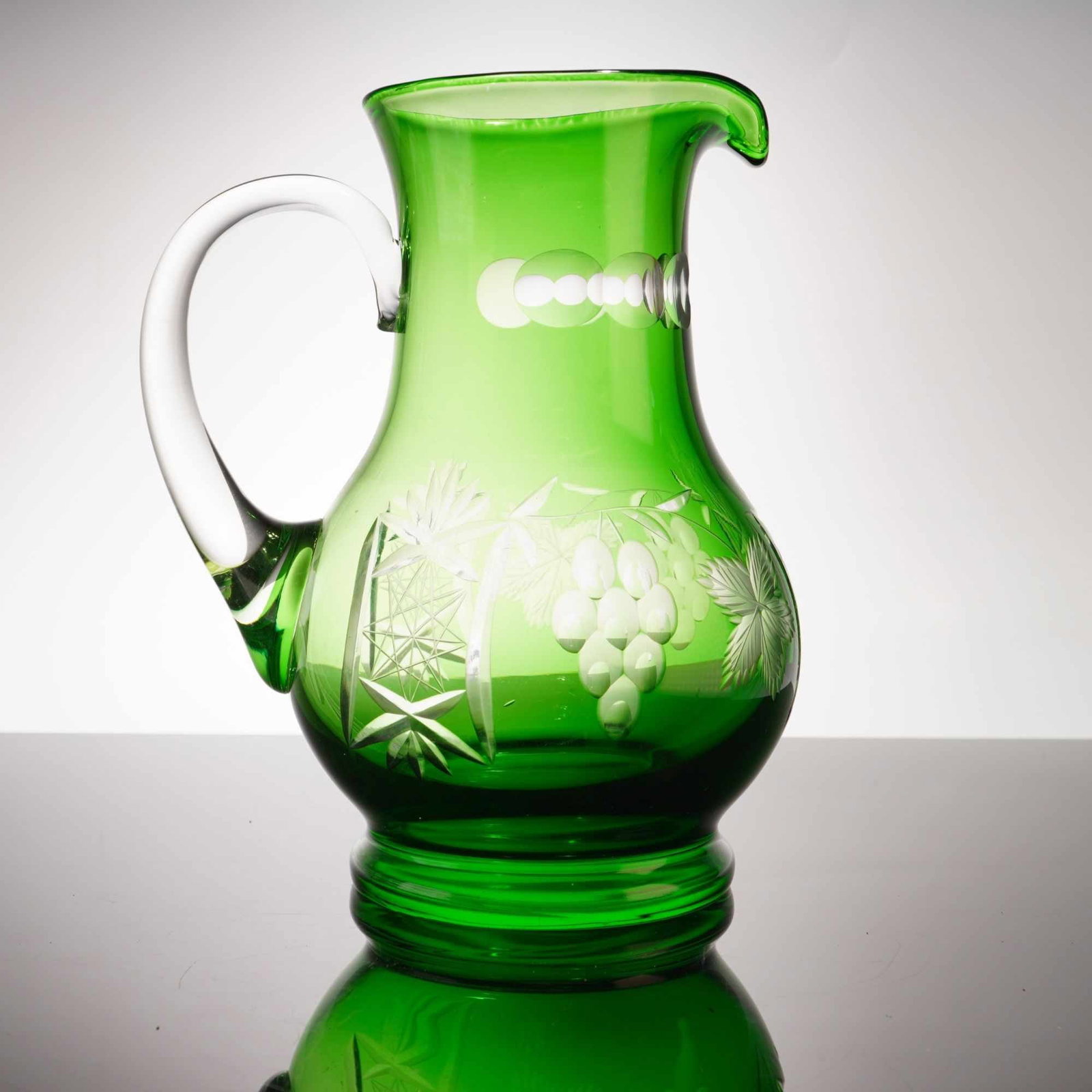 Vintage Green Cut-to-Clear Glass Pitcher, Floral: A striking example of traditional cut?to?clear craftsmanship, this vintage green glass pitcher features a beautifully executed floral design that catches the light with exceptional clarity. The deep e
