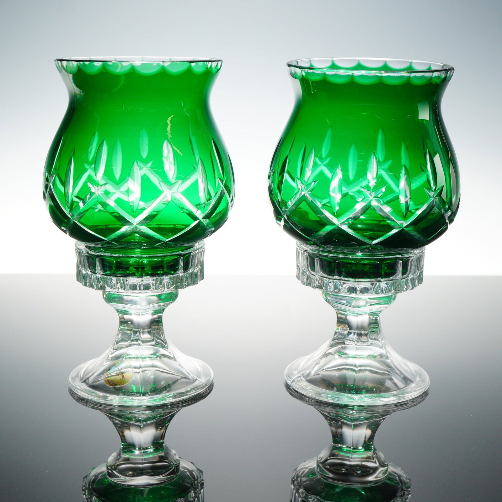 Gorham Lady Anne Hurricane Pair Cased Emerald Green Candle Holders with Box: A set of two contemporary hurricane lamps by Gorham in the Lady Anne pattern. Each two-piece unit consists of an emerald green cased glass shade and a clear crystal pedestal base. The shades are decor