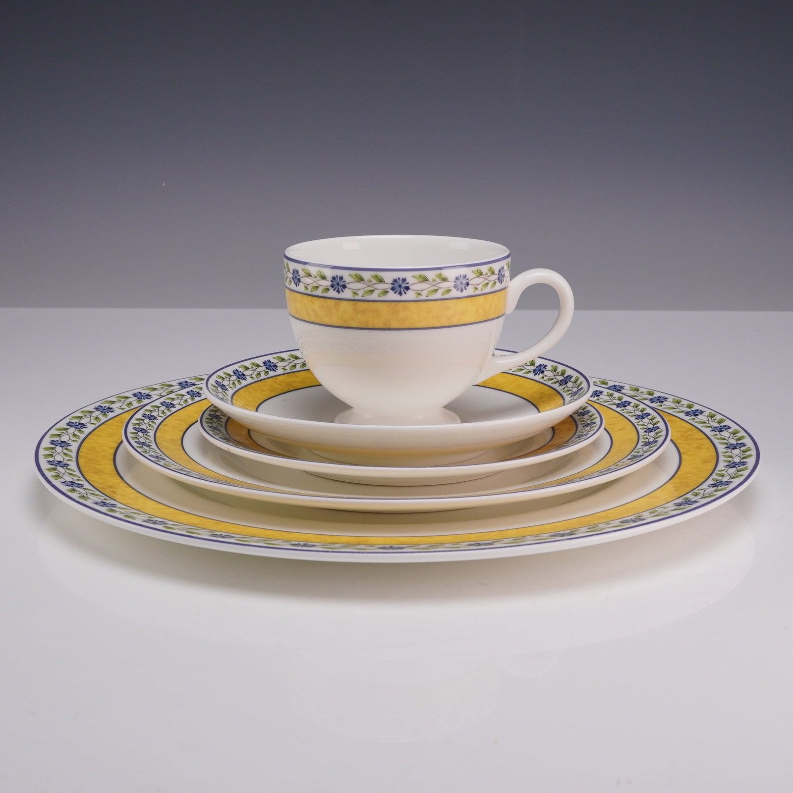 5-Piece Wedgwood Bone China Set of Plates and Teacup, Mistral: This 5-piece Wedgwood Mistral china set consists of a dinner plate, a salad plate, a bread and butter plate, a teacup, and a saucer. Produced in England, the pattern was introduced in 1994. The pieces