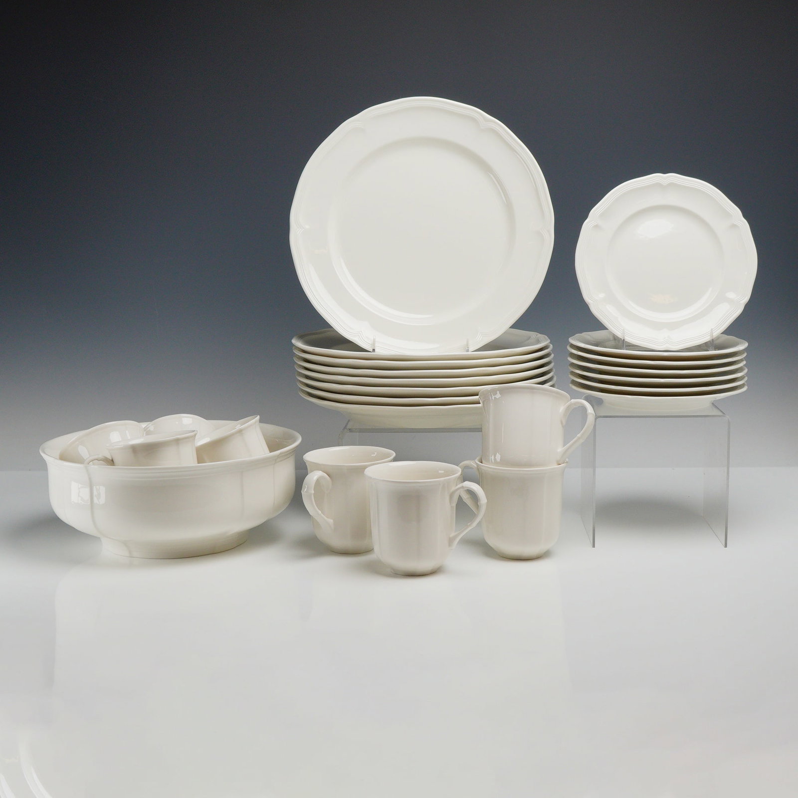 24pc Villeroy & Boch Chambord Fine China Dinnerware Set: A twenty-four piece grouping of fine china dinnerware by the German manufacturer Villeroy & Boch in the Chambord pattern. Each piece is finished in a uniform white glaze and features a scalloped or lo