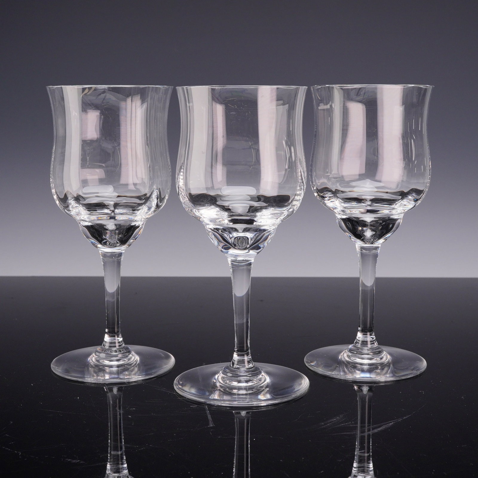 3pc Baccarat Capri Optic Crystal Tall Water Goblets: This set of three lead crystal tall water or wine goblets is in the Capri Optic pattern by Baccarat, France. Each glass features a bell-shaped bowl with internal vertical optic ribbing that flares sli