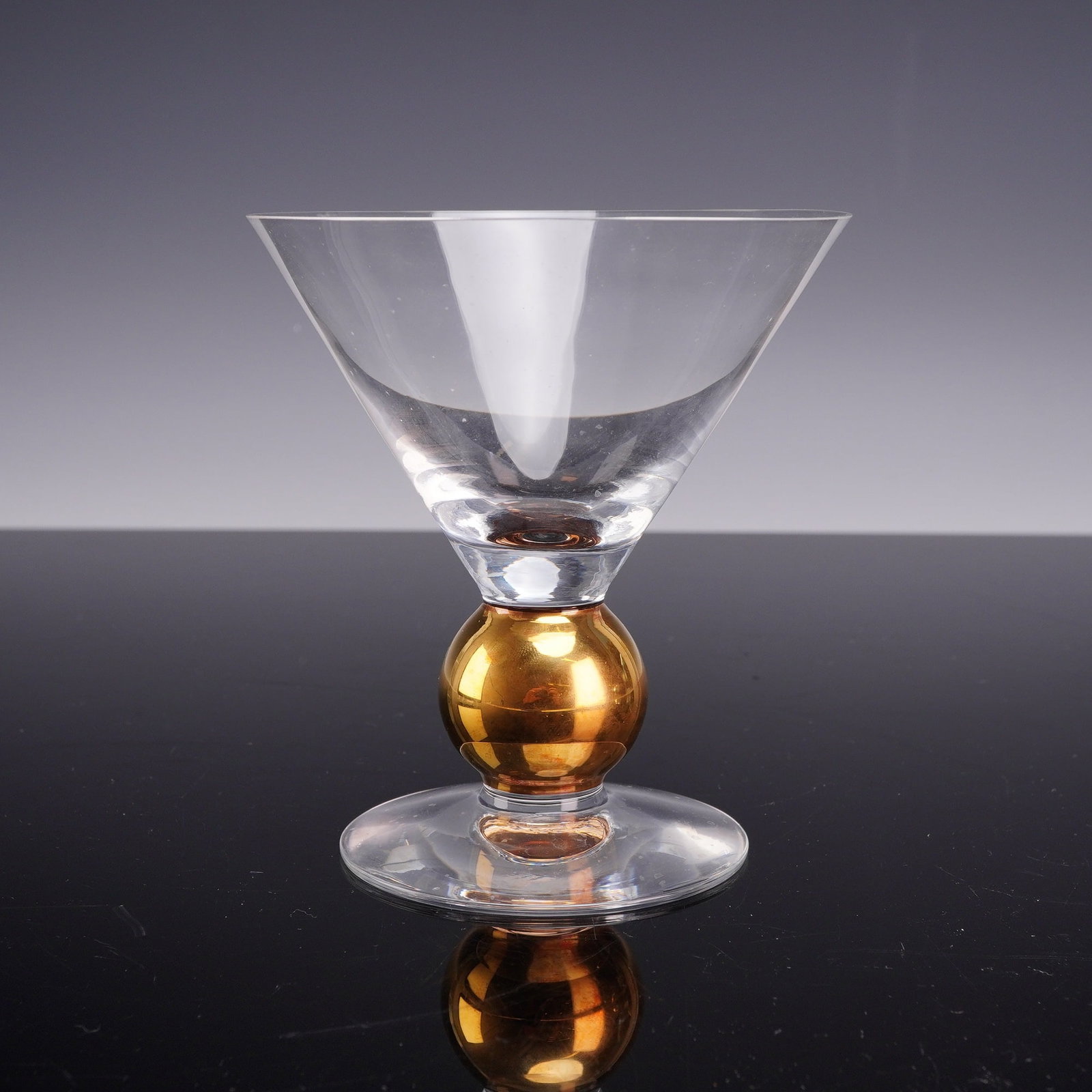 Orrefors Nobel Series Crystal Martini Glass with 21 Karat Gold Knop: An Orrefors Nobel series crystal martini glass designed by Gunnar Cyren. The piece is hand-blown and features a clear, conical bowl set atop a short stem. The stem is characterized by a prominent sphe