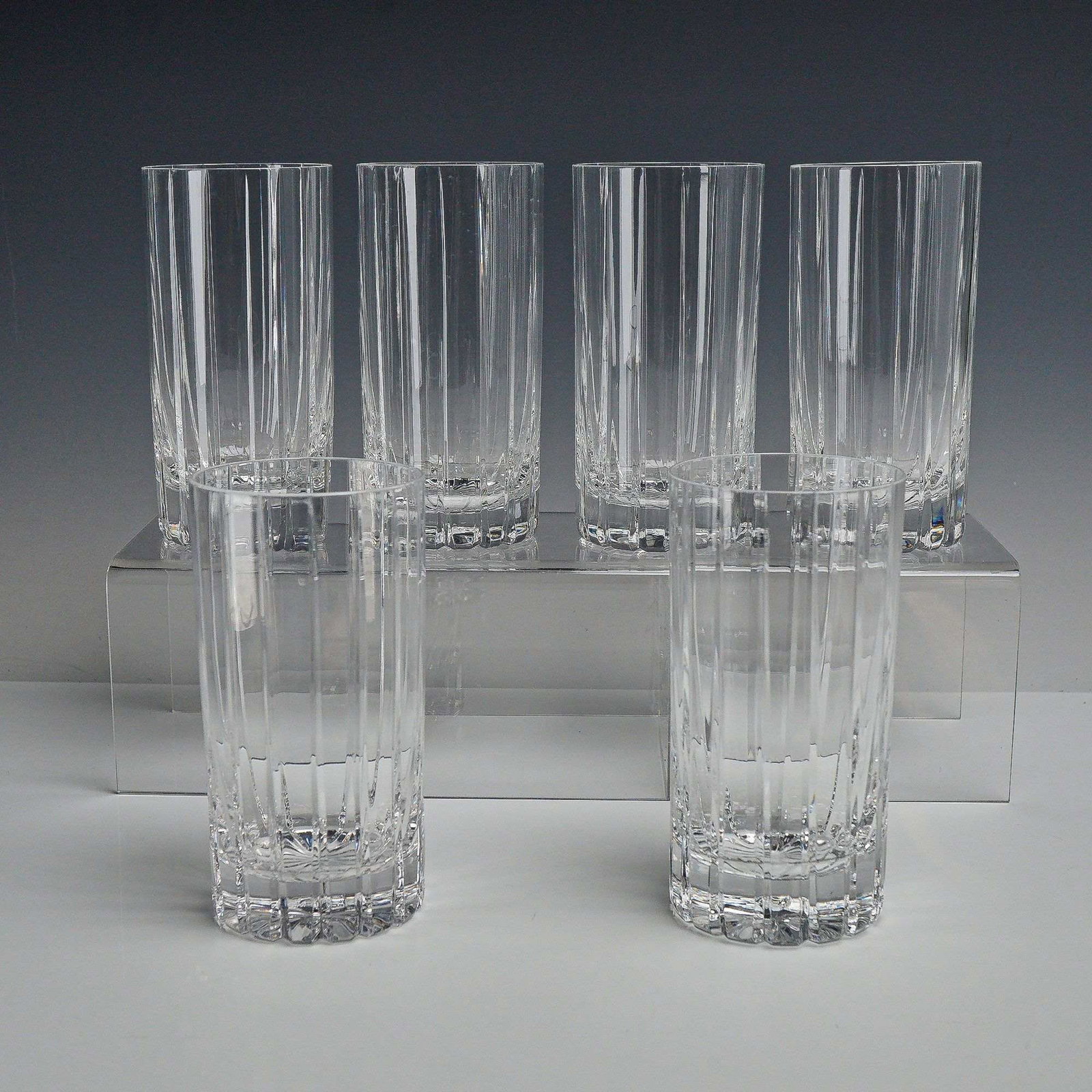 6pc Lead Crystal Highball Glasses with Vertical Mitered Cuts: A set of six highball or tall tumbler glasses crafted from 24% lead crystal. The glasses feature a minimalist design consisting of deep, vertical mitered cuts extending from just below the rim to the