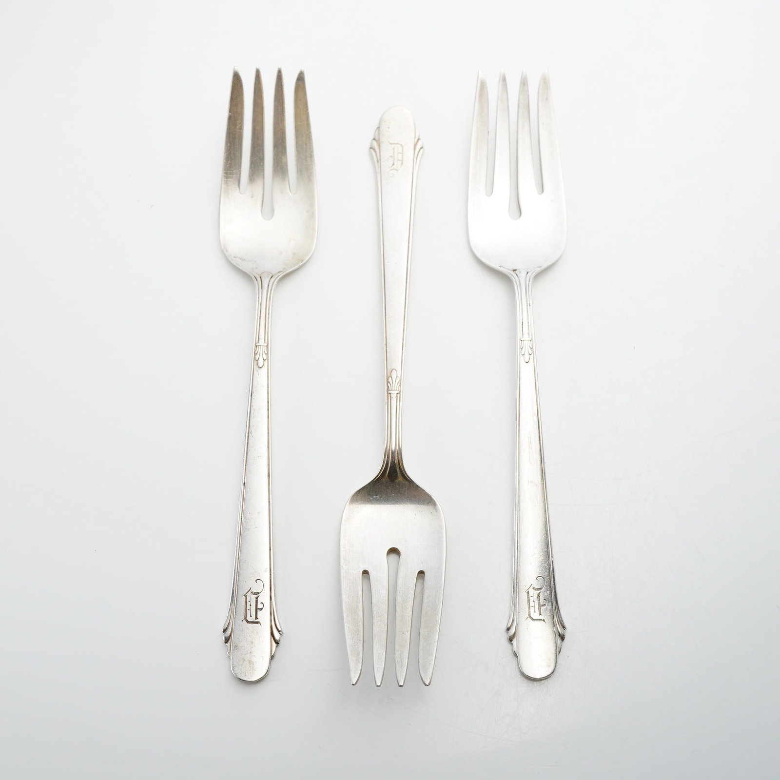 Three Gorham Sterling Silver Forks, Hunt Club Pattern: A lot of three sterling silver forks manufactured by Gorham in the Hunt Club pattern. Introduced in 1930, this Art Deco design features clean lines with slightly flared handles, notched terminals, and