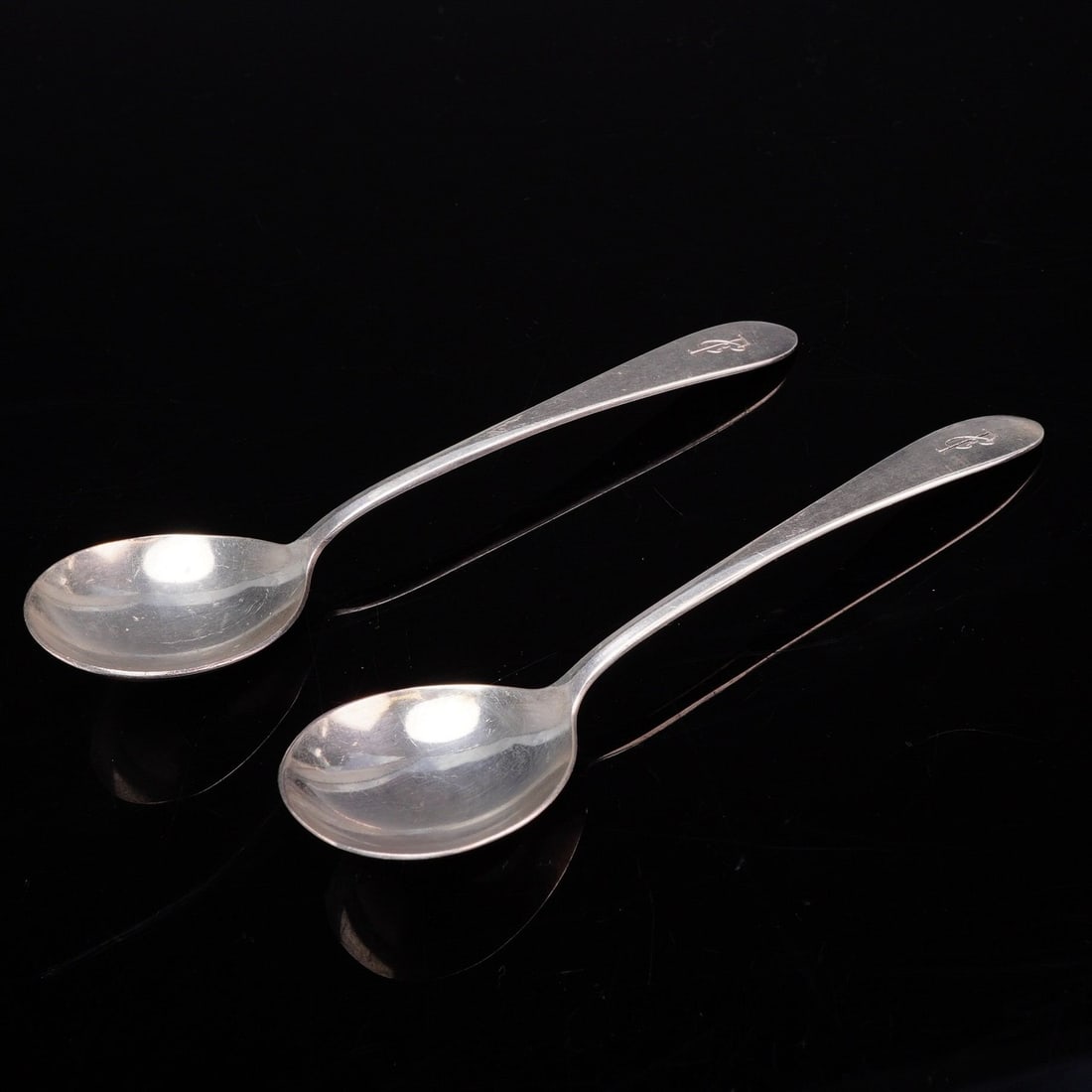A Pair of International Silver Co. Silver-Plated Spoons: A pair of silverplated spoons by the International Silver Company. The spoons feature rounded bowls typical of bouillon or cream soup service. Each handle has a tapering form ending in a point and is 