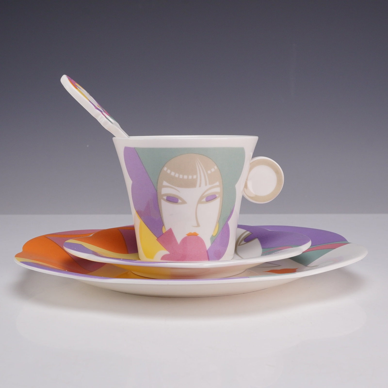 4 Piece Sango Larry Laslo Dessert Set - Plate, Saucer, Teacup and Stirrer, Visage: This four-piece china set is from The Larry Laslo Collection for Sango in the Visage pattern. The set consists of a luncheon plate, a saucer, a teacup, and a ceramic spoon or stirrer. The porcelain pi
