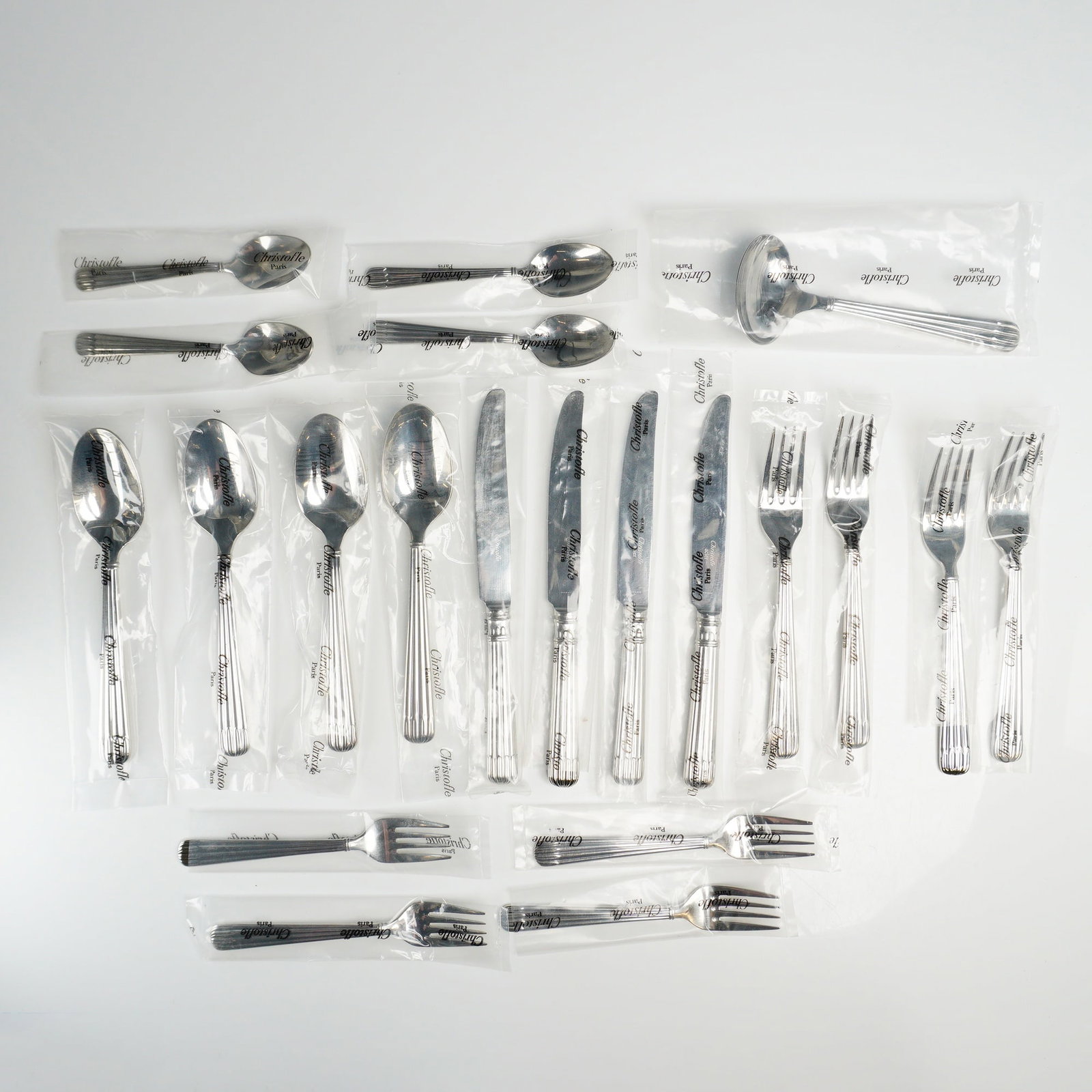 21pc Christofle Laguna Acier Stainless Steel Flatware Set for Four: A 21 piece stainless steel flatware service for four in the Laguna pattern produced by Christofle, France. The set comprises four dinner forks, four salad forks, four dinner knives, four spoons, and f