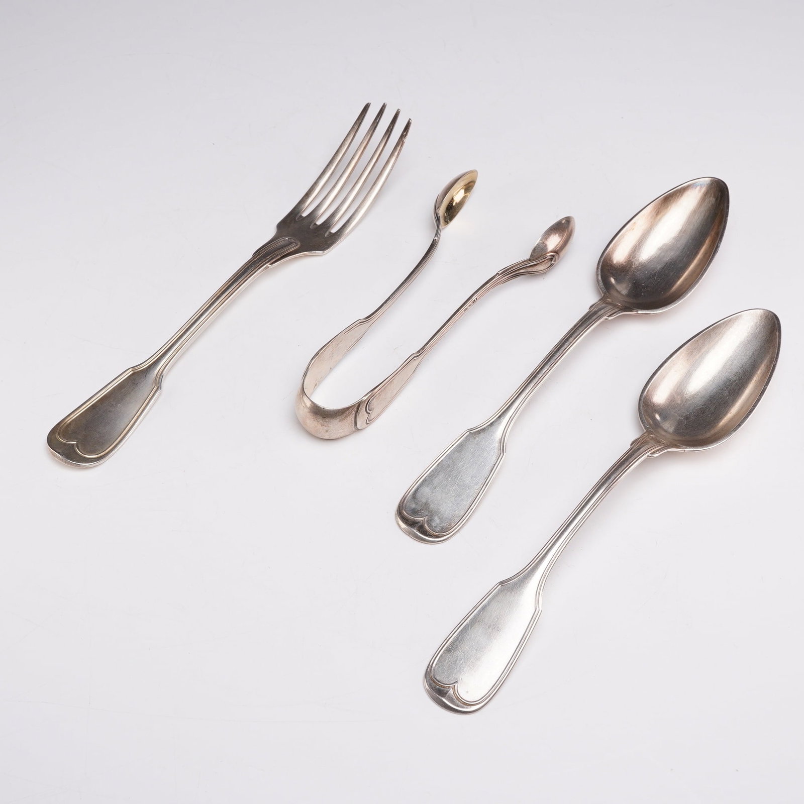 4pc Assorment of 800 Silver and Christofle Silverplate Utensils: This group includes two serving spoons and one pair of sugar tongs, both marked 800 on the reverse. It also includes one silverplated Christofle fork, which has its respective hallmarks on the reverse