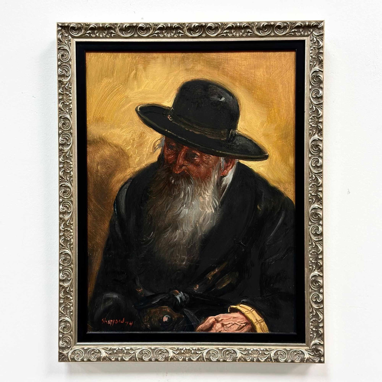 Joseph Sherly Sheppard (American, b. 1930) Oil on Board, Portrait of a Rabbi, 1974: This oil on board painting by Joseph Sherly Sheppard (American, b. 1930) is a portrait study of a Rabbi, featuring a voluminous white beard, a black wide-brimmed hat, and a dark coat. The composition 