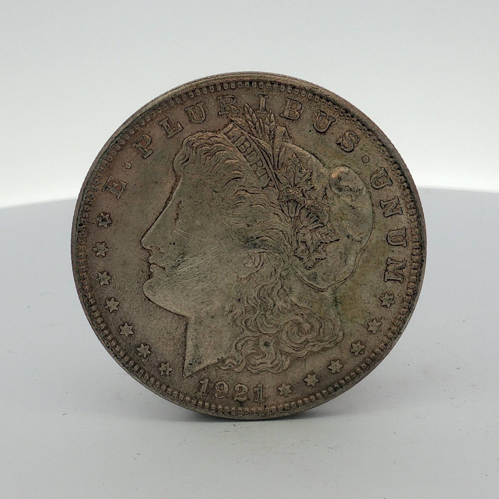1921 US Morgan Silver Dollar Coin Circulated: This Philadelphia Mint issue is struck in 90% silver and 10% copper. The coin features the Morgan design. Obverse inscriptions include E PLURIBUS UNUM and the date 1921. Reverse inscriptions include U