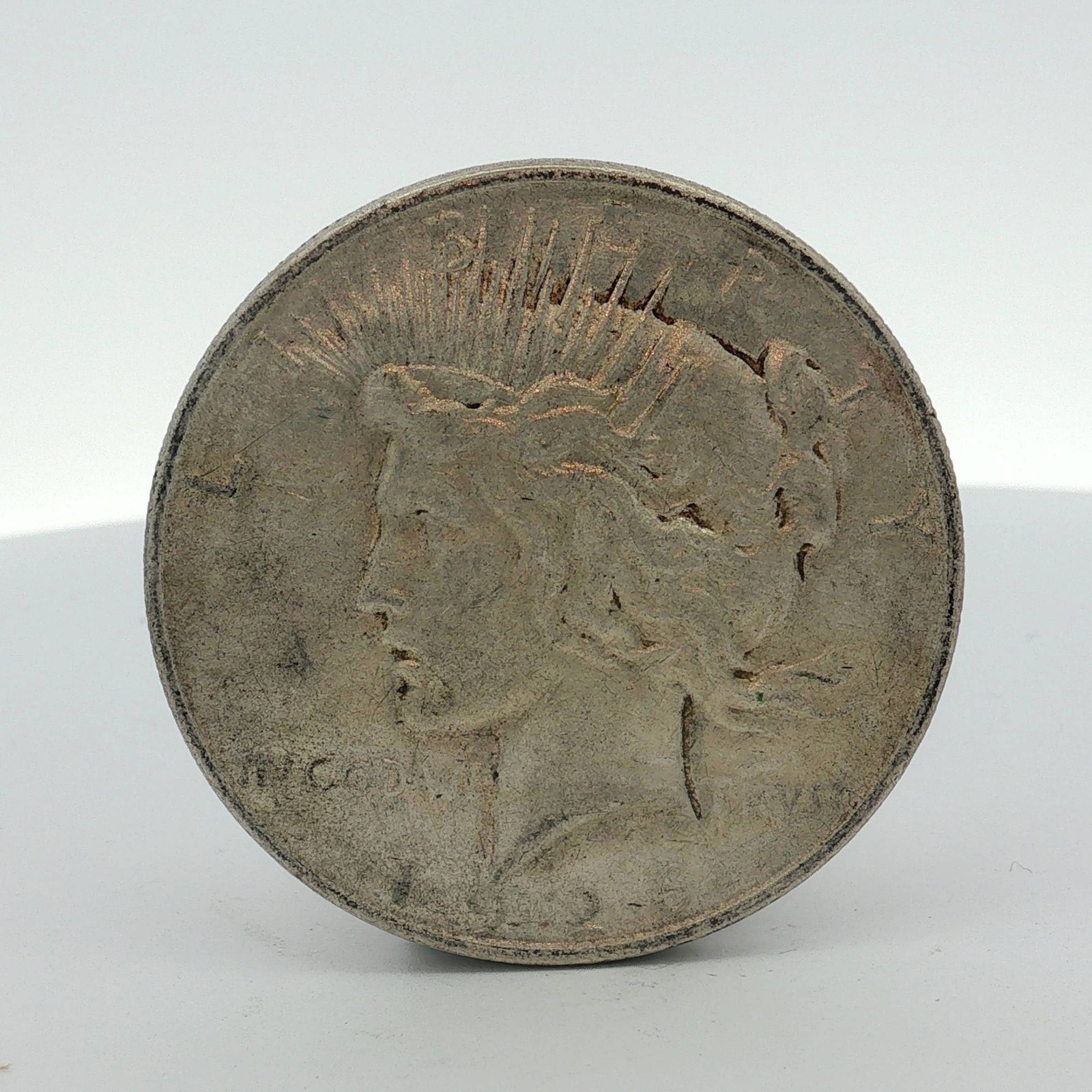 1922-D US One Dollar Peace Silver Dollar, Circulated: US Peace silver dollar was struck at the Denver mint. This coin is struck in 0.900 fine silver. The obverse features the Peace dollar Liberty head design with inscriptions LIBERTY and IN GOD WE TRUST.