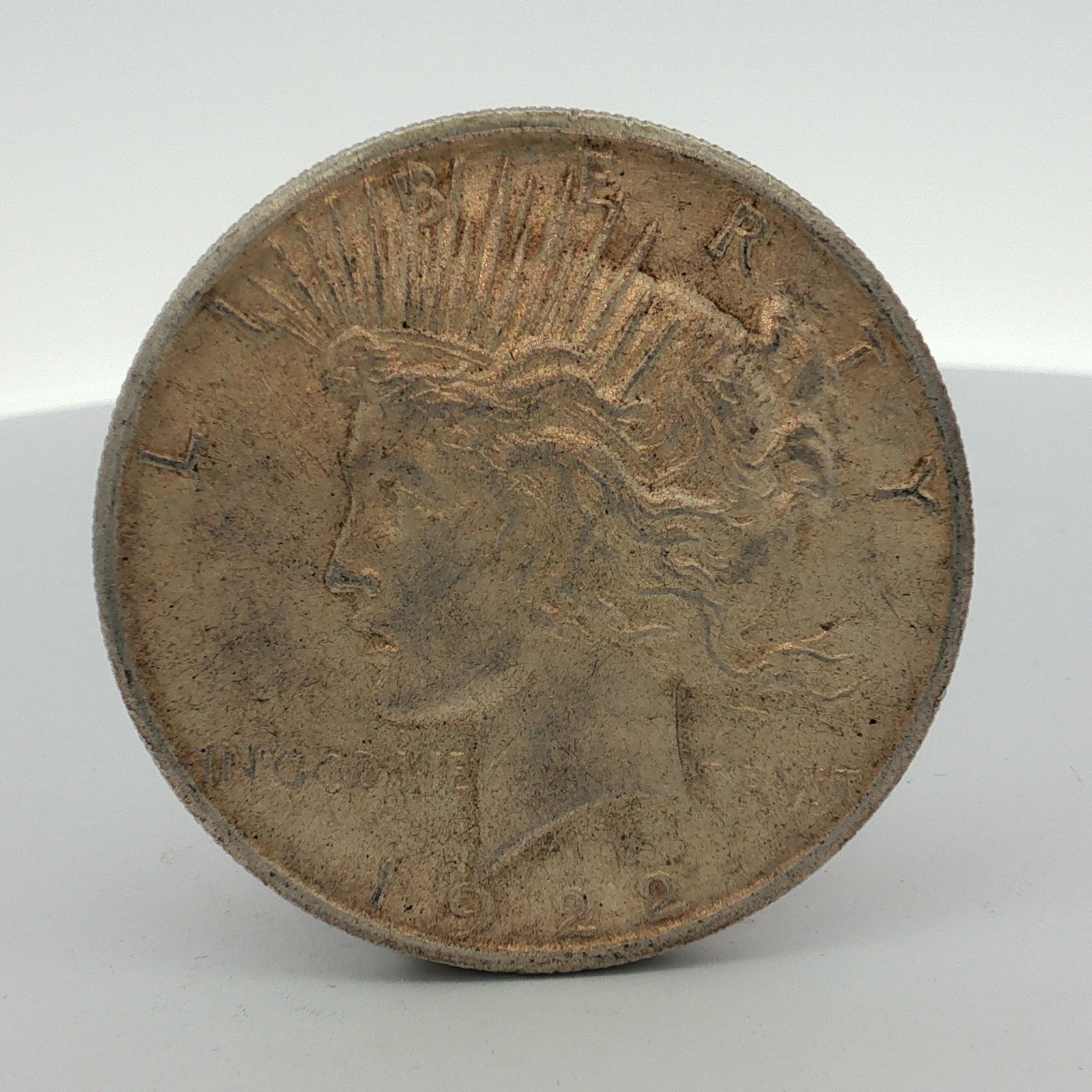 1922-S US One Dollar Peace Silver Dollar Coin, Circulated: This US Peace silver dollar, dated 1922, was struck at the San Francisco Mint as indicated by the S mint mark located on the reverse. The coin is composed of 90% silver and 10% copper. The obverse fea
