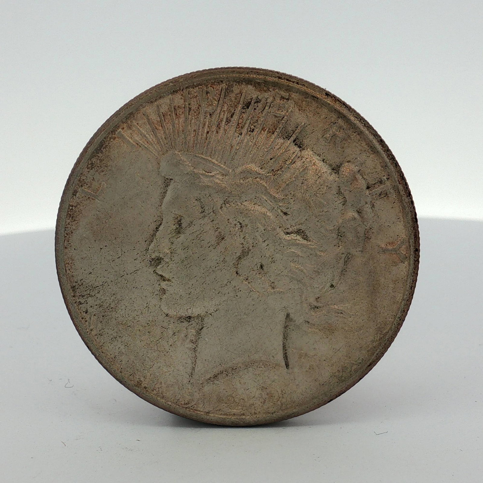 1923-S US Peace Silver Dollar: This US Peace silver dollar is dated 1923. The coin features the Liberty obverse and an eagle reverse. It was produced at the San Francisco Mint. The piece is composed of 0.900 fine silver with a copp