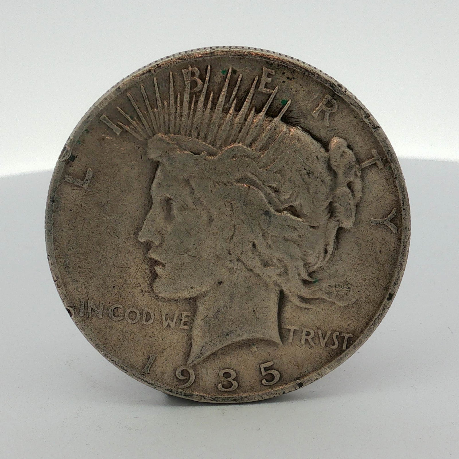 1935-S US One Dollar Peace Silver Dollar Coin, Circulated: This US Peace silver dollar is dated 1935 and was produced at the San Francisco Mint. The coin is struck in 90% silver and 10% copper, following the standard specifications for the series. The obverse