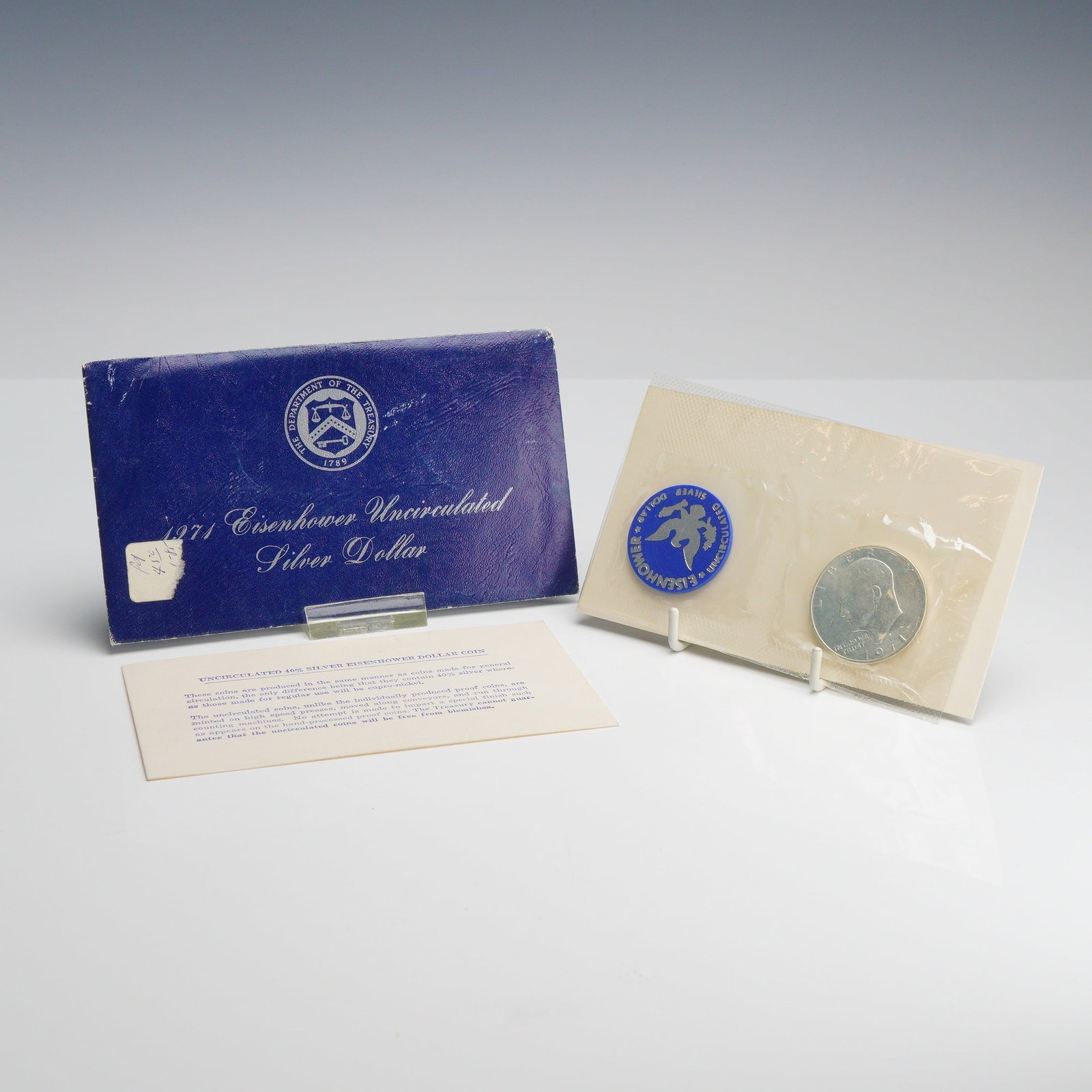 US 1971-S Eisenhower 40% Silver Dollar Uncirculated Blue Ike in Original Government Packaging: This 1971-S US Eisenhower 40% silver dollar is housed in its original government packaging, frequently called a Blue Ike. The coin was minted at the San Francisco facility, denoted by the S mint mark 