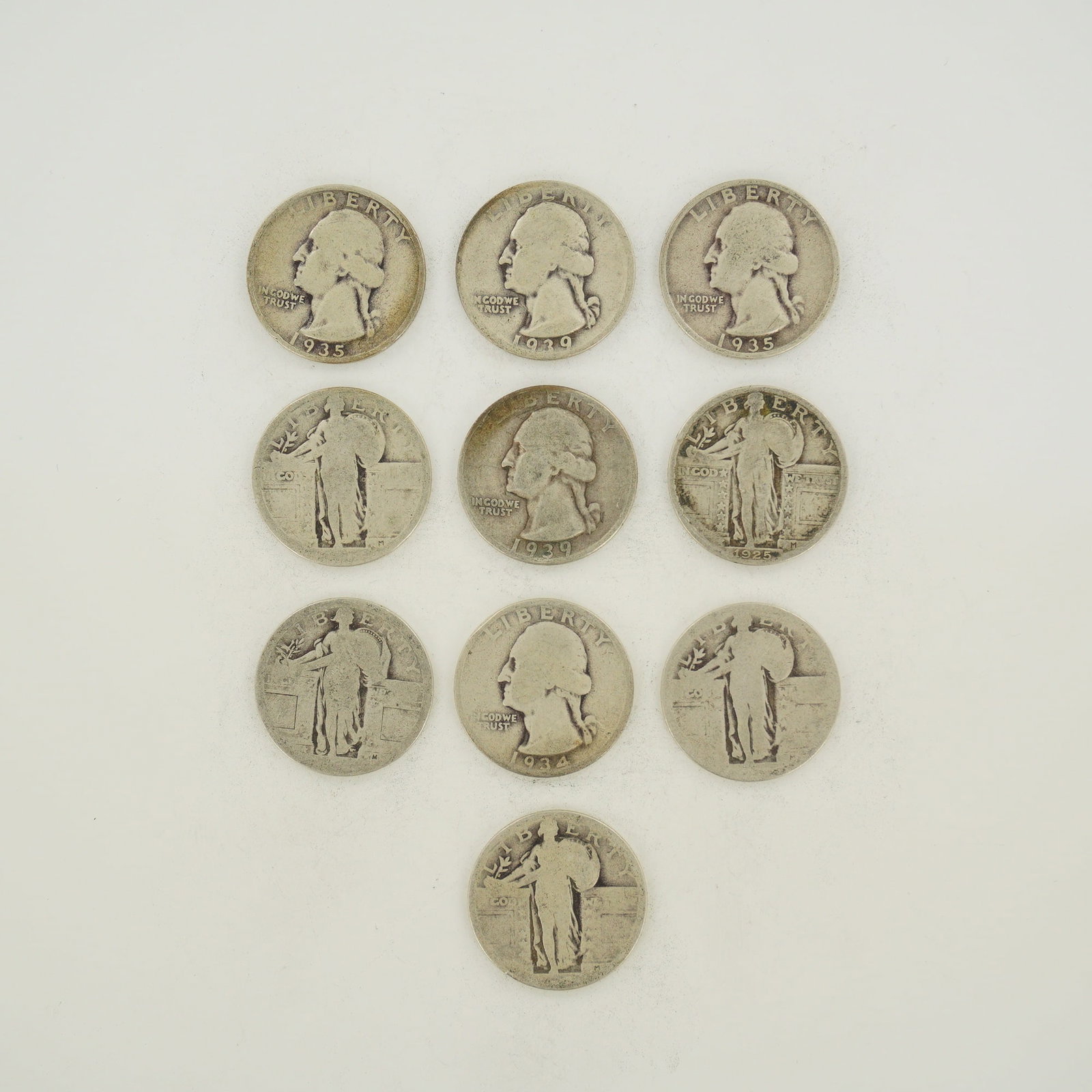 10pc Collection of US Silver Washington and Standing Liberty Quarters: A collection of US silver quarters featuring a mixed date bag of Washington and Standing Liberty types. The Washington quarters include examples dated 1934, 1935, and 1939. The Standing Liberty quarte