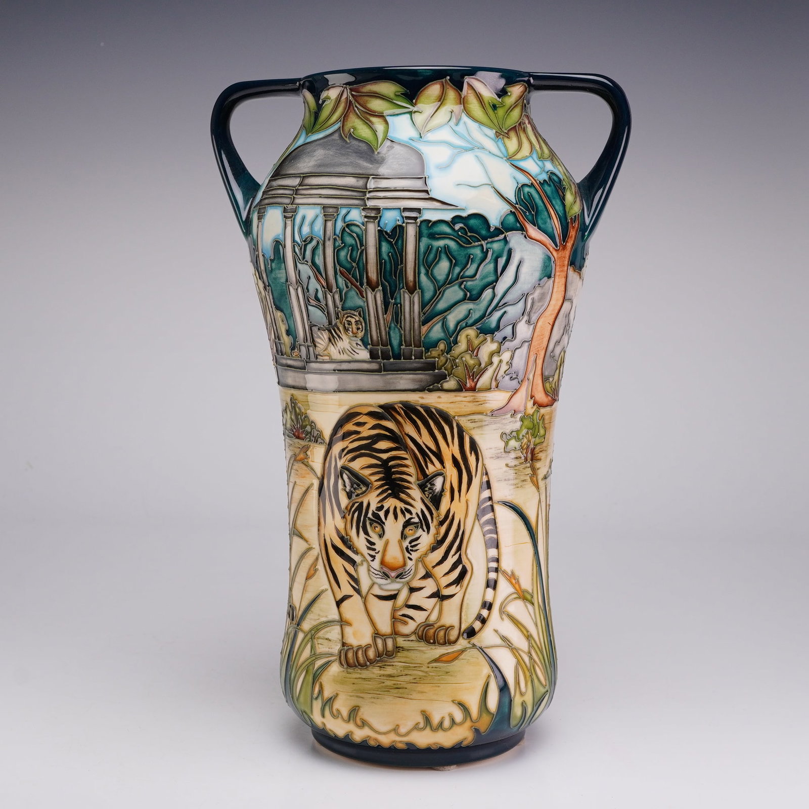 Moorcroft Pottery by Sian Leeper Limited Edition Two Handled Vase, Wild Grace: This is a large Moorcroft earthenware vase featuring a waisted body and two loop handles at the neck. The exterior is decorated with a detailed tiger themed landscape executed in the factory signature