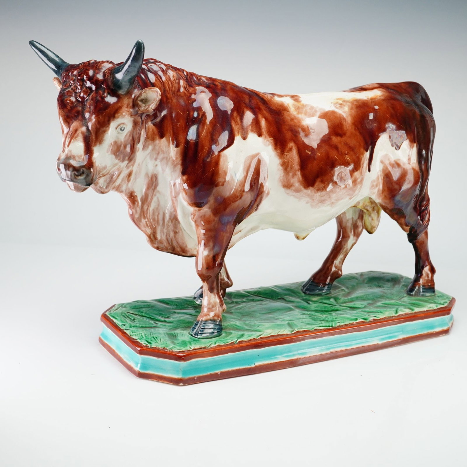 Large Wedgwood Glazed Creamware Bull Sculpture: This large-scale ceramic sculpture depicts a standing bull in a naturalistic pose with a forward-facing, slightly lowered head and powerful musculature, representing the Staffordshire pottery traditio