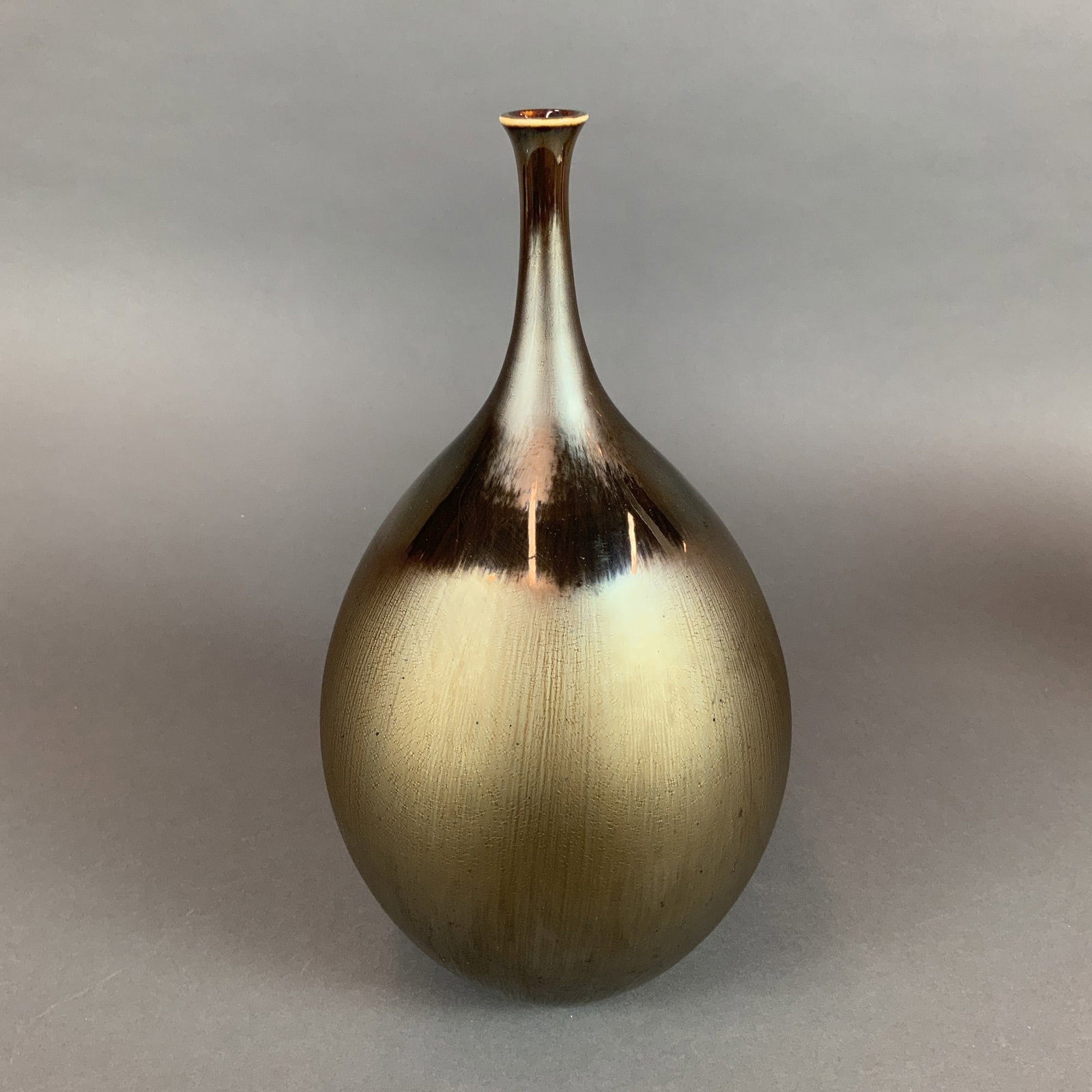 Hideaki Miyamura Porcelain Teardrop Vase with Metallic Luster Glaze: This contemporary porcelain vase by Hideaki Miyamura features a slender teardrop form with an elongated, narrow neck and a small flared rim. The exterior is finished in a metallic luster glaze that tr